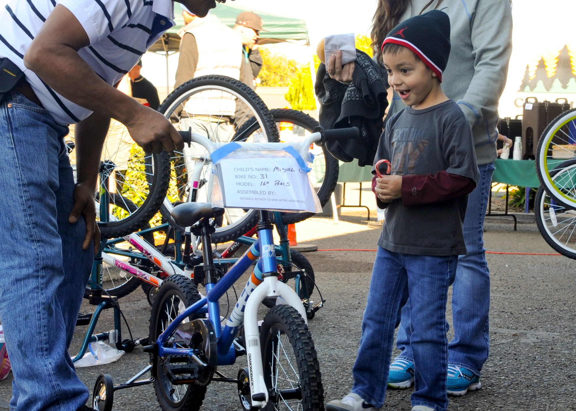 LOMPOC, Calif. – Miguel Landeros, son of currently deployed Tech. Sgt. Miguel Landeros, receives his bicycle during the annual Christmas Bikes for Vandenberg Air Force Base military children in Lompoc Saturday, Dec. 21, 2013. A local cycling group, The Village Dirtbags, provided over 100 bikes and helmets for families with deployed spouses and single income families. (U.S. Air Force photo/ Airman 1st Class Yvonne Morales)
