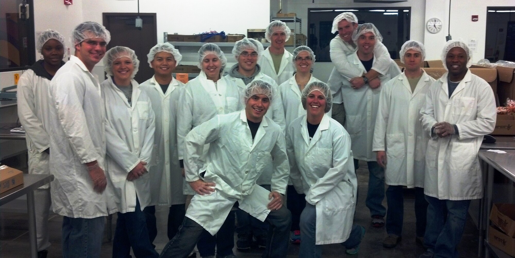 As part of their community outreach effort, the Kirtland Company Grade Officers Council helped the Albuquerque Roadrunner Food Bank in preparing donations Dec. 13 for local school lunch programs. The team consisted of CGOs from the Air Force Research Laboratory, the Air Force Operational Test and Evaluation Center, and the 377th Weapons System Security Squadron. From left to right: Front row: Lt. Dan McCarty, AFRL and Lt. Katie McCarty, AFOTEC. Middle row: Lt. Brent Danner and his wife Andrea, AFRL; Lt. Sue Lee, AFRL; Capt. Emily Purcell, AFRL; Capt. Shawn Hackett and his wife Jennifer, AFRL; Capt. Stephen Bump, AFRL; Capt. Mike LaSorda, AFRL; and Lt. Kevin Van Hook, AFRL. Back row: Lt. Dinishia Maldonado, 377 WSSS; Lt. Chris Frances, AFRL; and Lt. Curtis Christensen, AFRL. (Courtesy photo) 