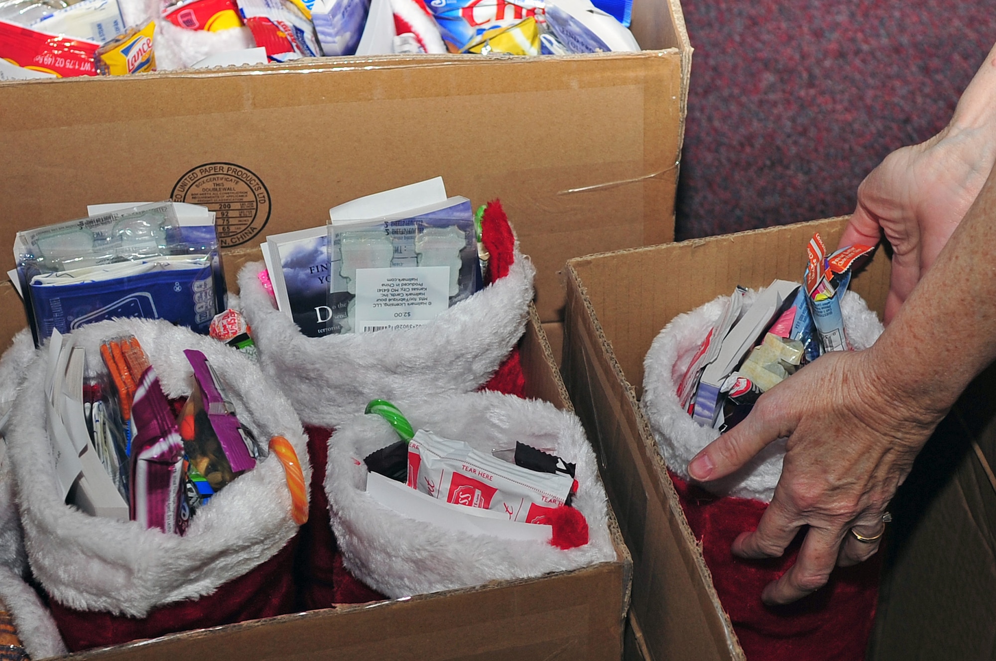 A volunteer prepares stockings for distribution to Airmen in the dorms at Seymour Johnson Air Force Base, N.C., Dec. 19, 2013. Every stocking had candy, nutrient bars and travel sized cosmetics for the Airmen. (U.S. Air Force photo by Airman 1st Class Shawna Keyes)
