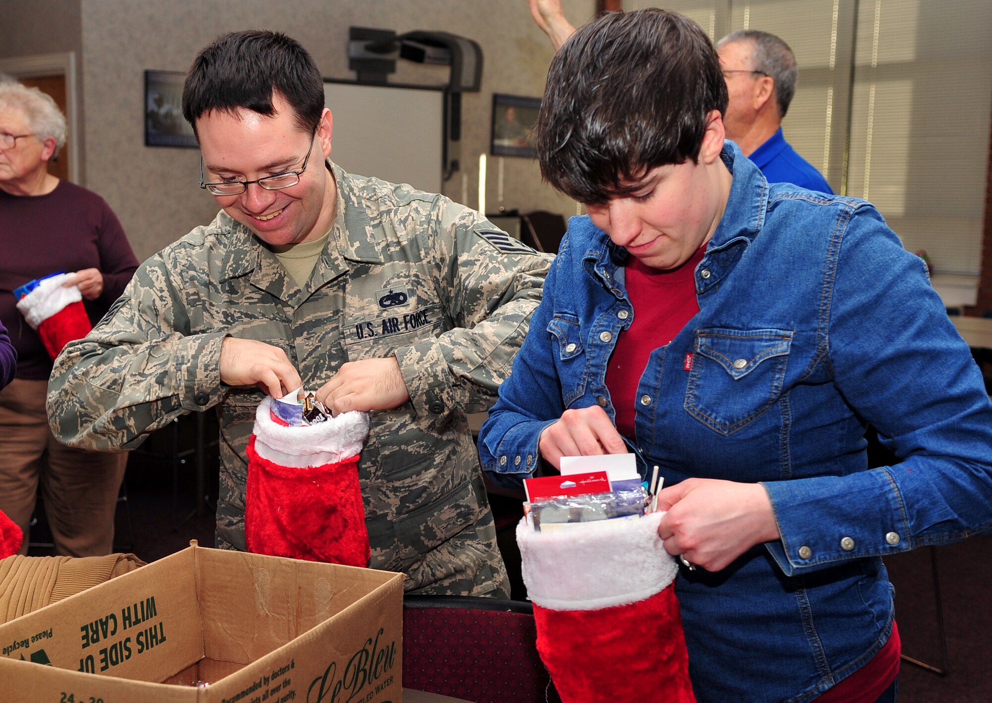 Staff Sgts. Richard Sexton, left, and Rebecca Shelton, 4th Component Maintenance Squadron avionics sensor technicians, fill stockings for Airmen in the dorms at Seymour Johnson Air Force Base, N.C., Dec. 19, 2013. The base chapel had 25 volunteers stuff stockings, with items donated by the chapel and its base personnel. (U.S. Air Force photo by Airman 1st Class Shawna Keyes)       