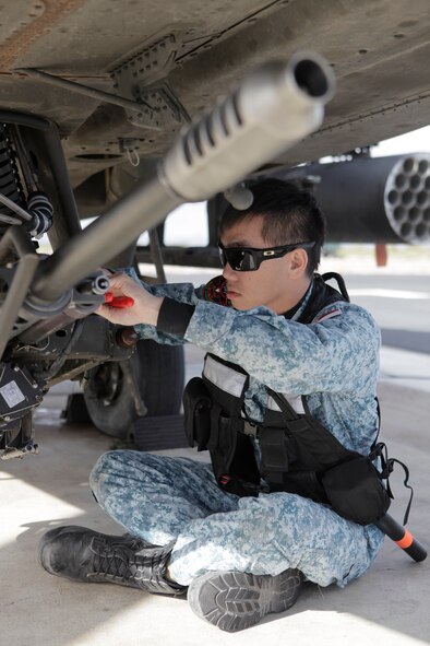 A Republic of Singapore air force weapons technician completes functional checks on an AH-64 Apache gun system at the Gila Bend Air Force Auxiliary Field prior to a live-fire mission on the BMGR. (Courtesy photo)