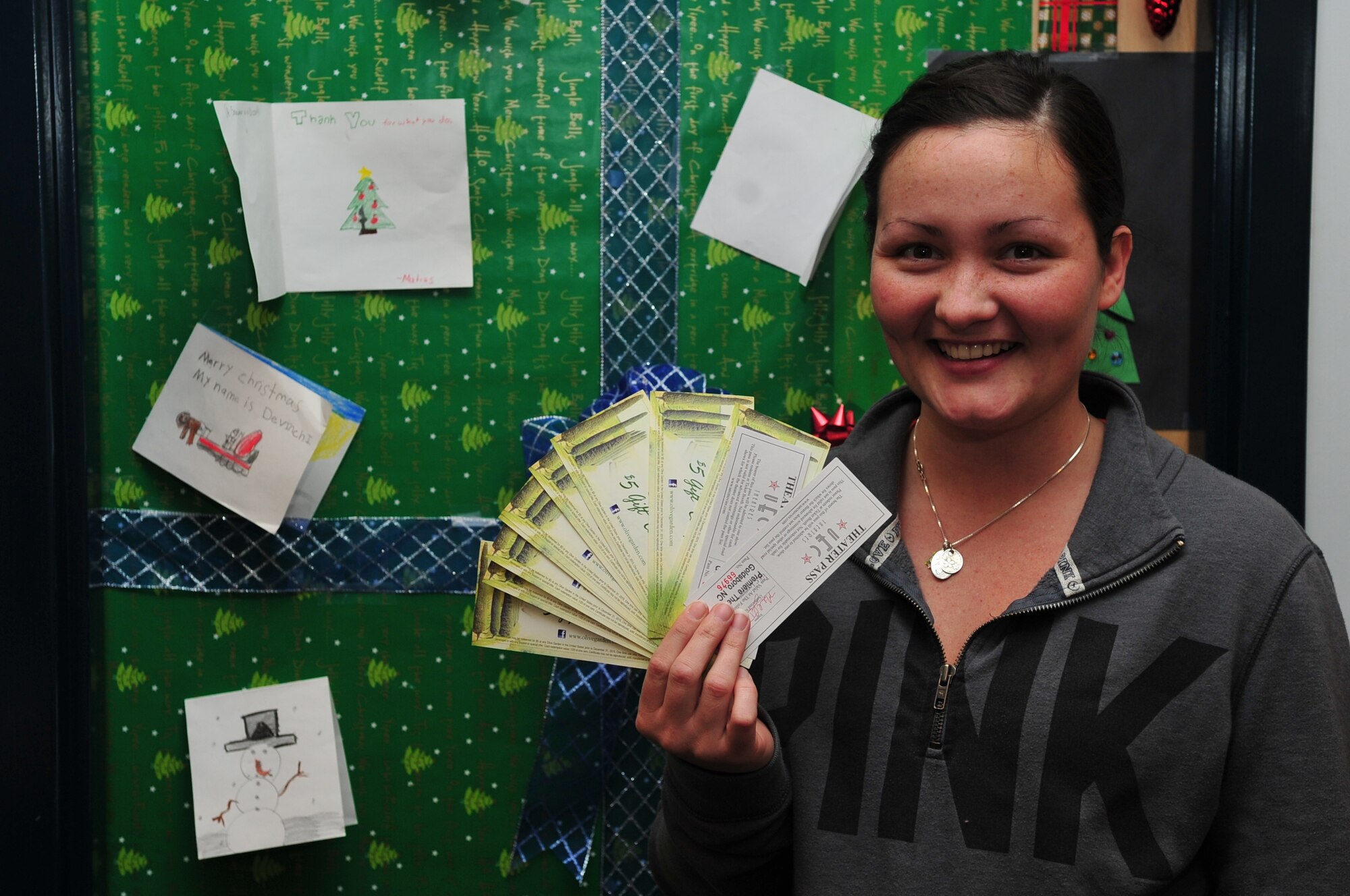 Airman 1st Class Brittanie Seay, 4th Operations Support Squadron air traffic controller apprentice, shows her award for placing first in the holiday dorm room door decoration contest at Seymour Johnson Air Force Base, N.C., Dec. 19, 2013. Judges unanimously selected the winning door for its creative and humorous approach to holiday decoration. (U.S. Air Force photo by Airman 1st Class Aaron J. Jenne)