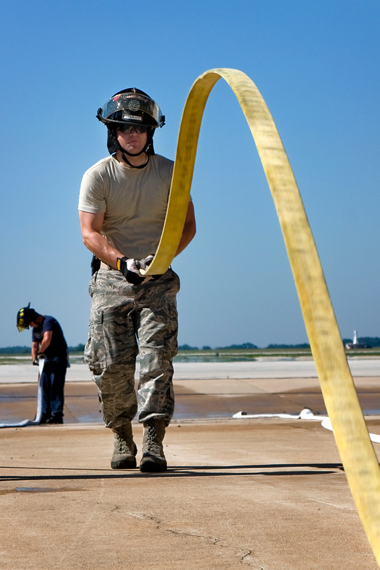 Senior Airman Kenneth W. Pinaire Jr., 434th Civil Engineer Squadron firefighter, positions a fire hose for pressure testing at Grissom during his seasoning training July 12, 2013. The Grissom Fire Department is comprised of both civilian and military reservist firefighters, who work and train together as one team to protect the base and the local community. 