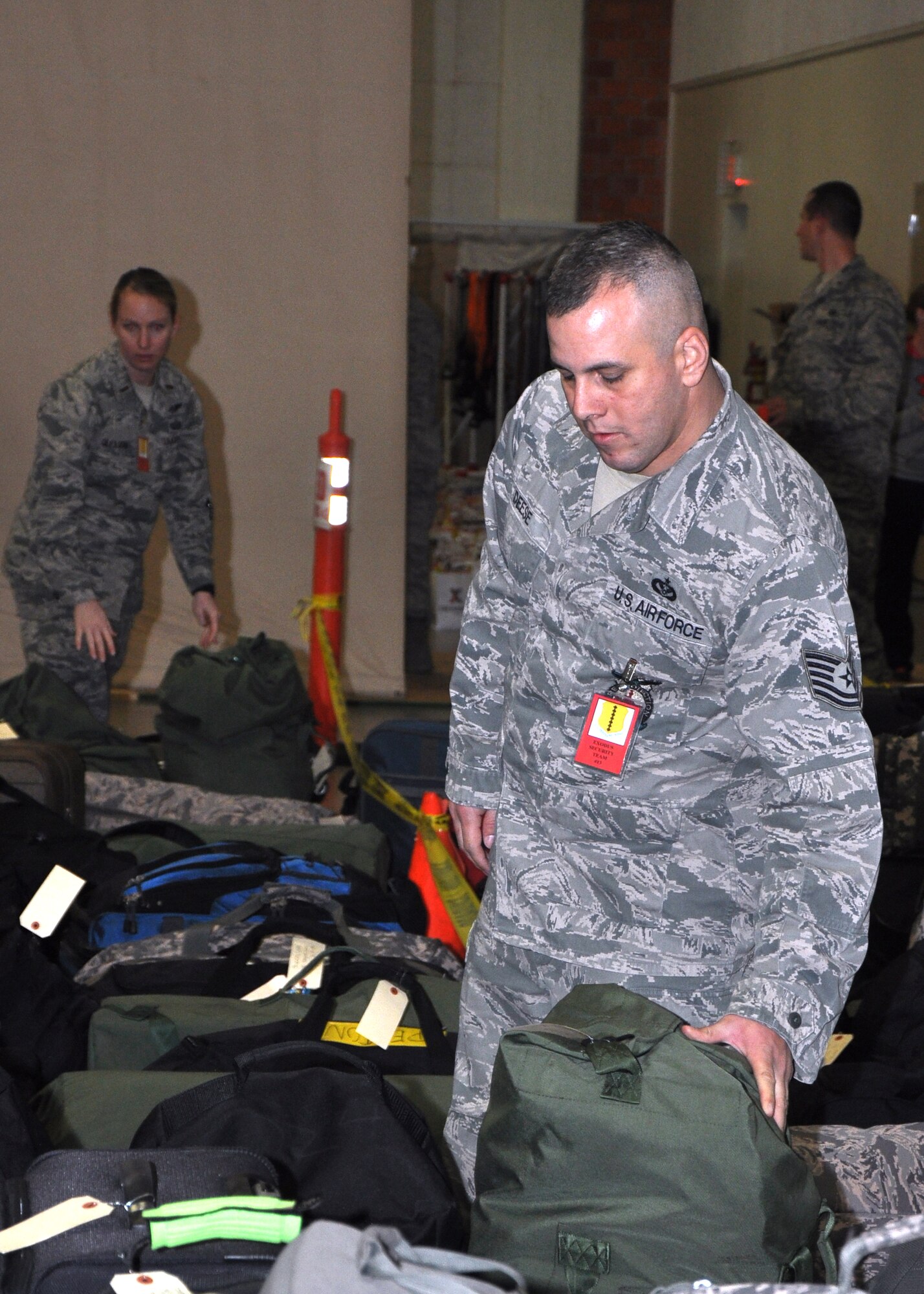 GOODFELLOW AIR FORCE BASE, Texas – Tech. Sgt. John Deese, 312th Training Squadron instructor, arranges student luggage during his volunteer shift at the Carswell Field House Dec. 20. Volunteers helped ensure baggage made it into the right queue lines, students properly signed in and everyone rode the right bus for exodus, the annual release for the winter holidays. (U.S. Air Force photo/ Senior Airman Joshua Edwards)