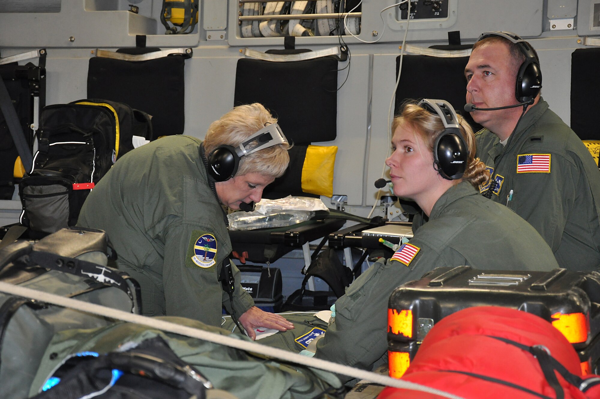 Master Sgt. Alex Evanosky (left), an aeromedical evacuation technician assigned to the 315th Aeromedical Evacuation Squadron, Joint Base Charleston, S.C., watches over a patient who poses as a victim of a heart attack while 1st. Lt. Howard Crowley (middle), a flight nurse and Tech. Sgt. Michelle Geers (right), an aeromedical evacuation technician, monitor the patient's vital signs. Members of the 315 AES conducted training aboard a C-17 Globemaster III aircraft en route to Incirlik Air Base, Turkey Dec. 19, 2013. (U.S. Air Force photo by Maj. Wayne Capps/released)   