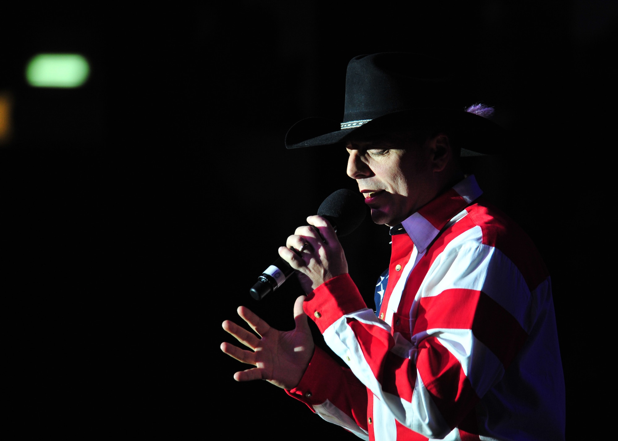 Ryan Daniel, a vocalist for the 'Gift of Music' tour with the Air Force Entertainment Group, sings at a performance for the 380th Air Expeditionary Wing at an undisclosed location in Southwest Asia, Dec. 19, 2013. Daniel served in the Air Force for more than nine years and was a member of the 2001 edition of Tops in Blue. All of the performers are alumni of previous Tops in Blue shows. (U.S. Air Force photo by Staff Sgt. Michael Means/Released)