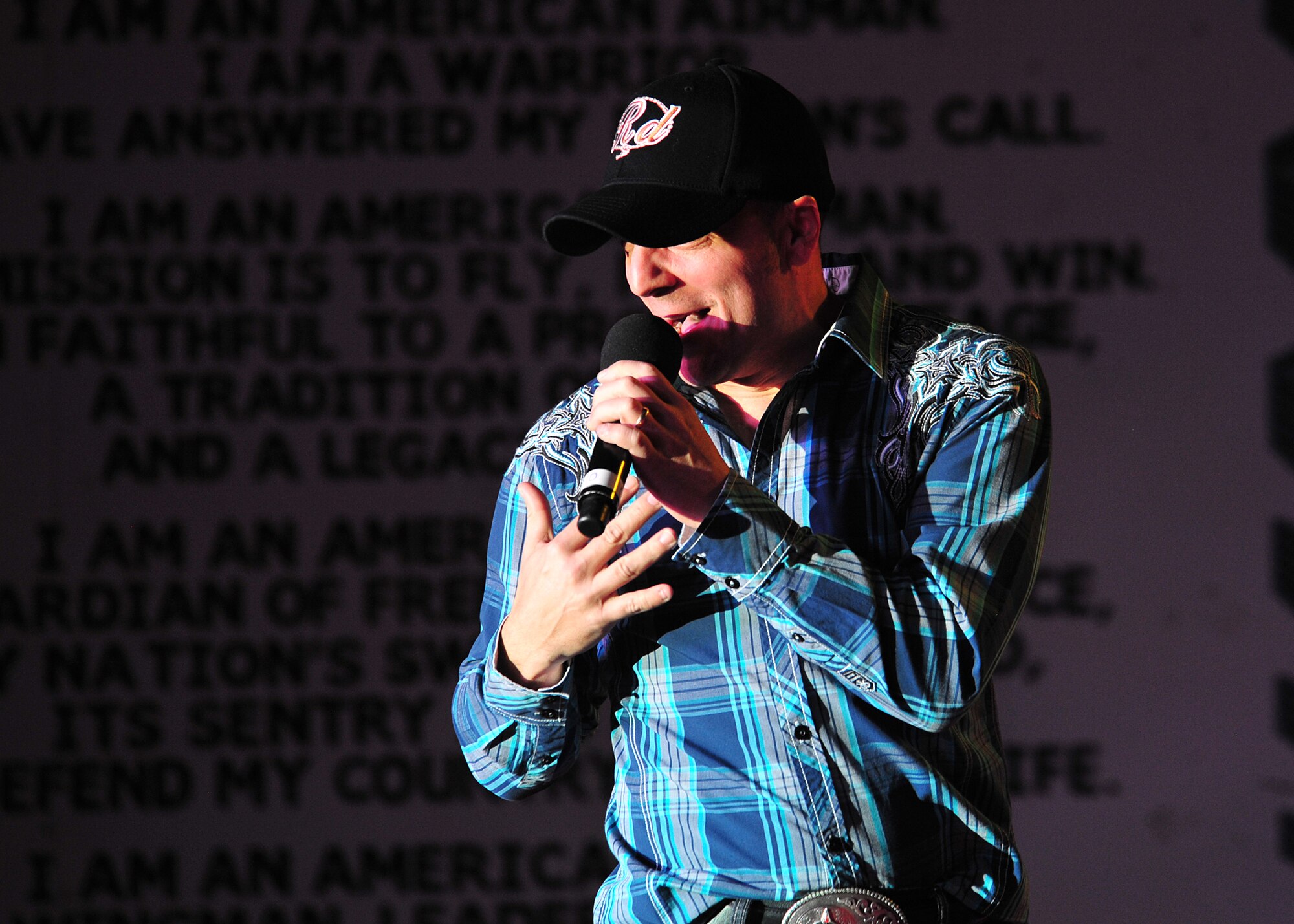 Ryan Daniel, a vocalist for the 'Gift of Music' tour with the Air Force Entertainment Group, sings during a performance for the 380th Air Expeditionary Wing at an undisclosed location in Southwest Asia, Dec. 19, 2013. Daniel served in the Air Force for more than nine years and was a member of the 2001 edition of Tops in Blue. All of the performers are alumni of previous Tops in Blue shows. (U.S. Air Force photo by Staff Sgt. Michael Means/Released)