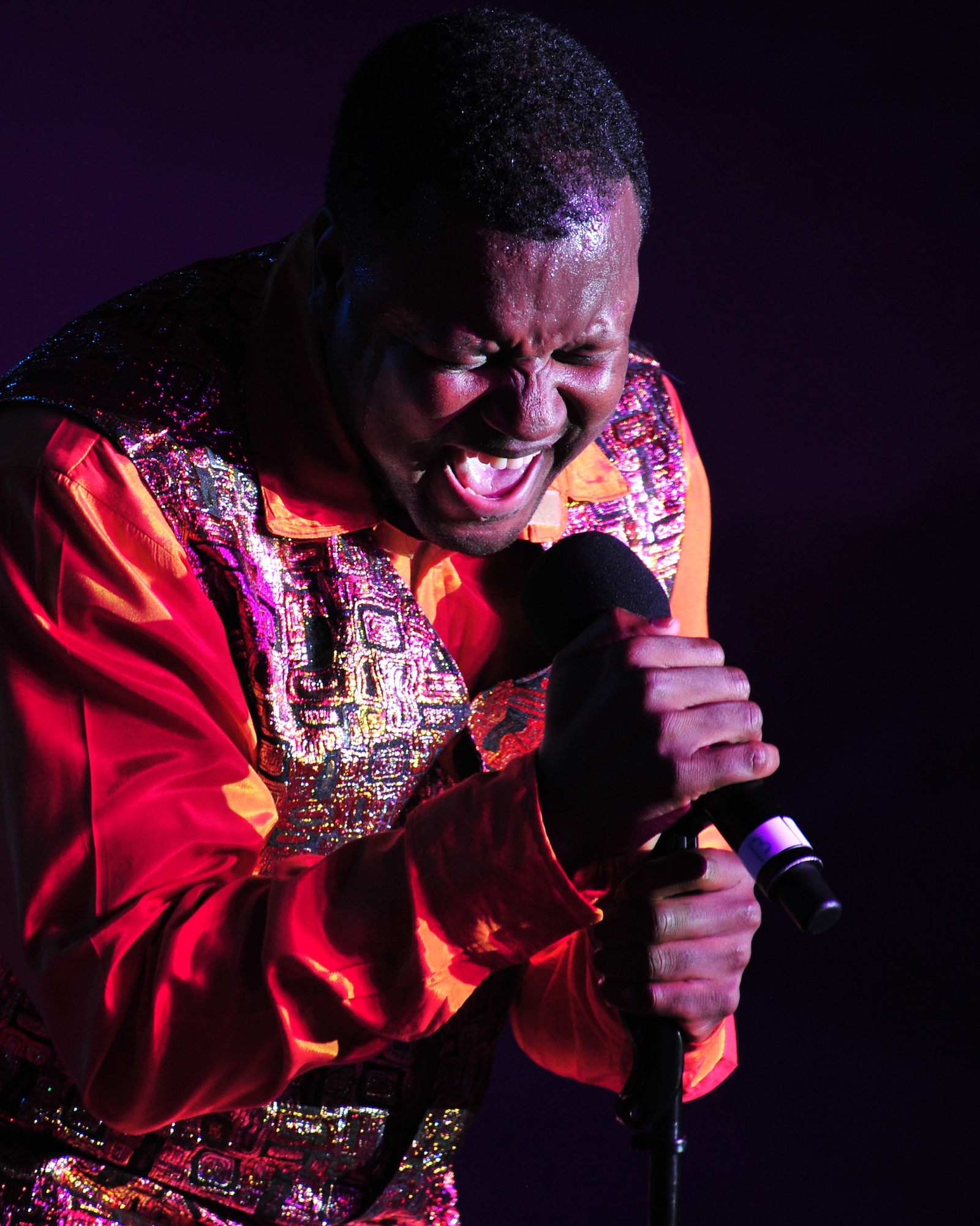 Edward Lee Jones, vocalist and performance director for Air Force Entertainment Group, sing for members of the 380th Air Expeditionary Wing during the 'Gift of Music' holiday tour at an undisclosed location in Southwest Asia, Dec. 19, 2013. (U.S. Air Force photo by Staff Sgt. Michael Means/Released)