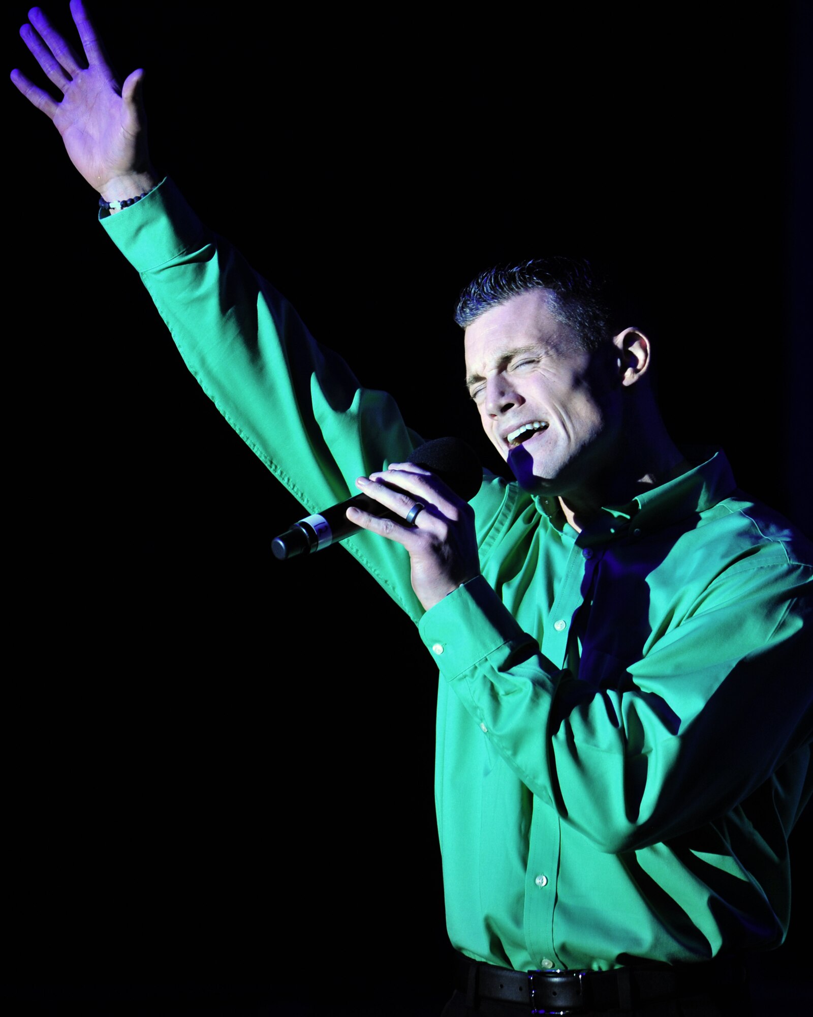 Air Force Capt. Robert Doyle, vocalist for the 'Gift of Music' tour with Air Force Entertainment Group, sings at a performance for the 380th Air Expeditionary Wing at an undisclosed location in Southwest Asia, Dec. 19, 2013. Doyle was a member of the 2011 Tops in Blue World Tour. He is currently stationed at Los Angeles Air Force Base, Calif. All of the performers are alumni of previous Tops in Blue shows. (U.S. Air Force photo by Staff Sgt. Michael Means/Released)
