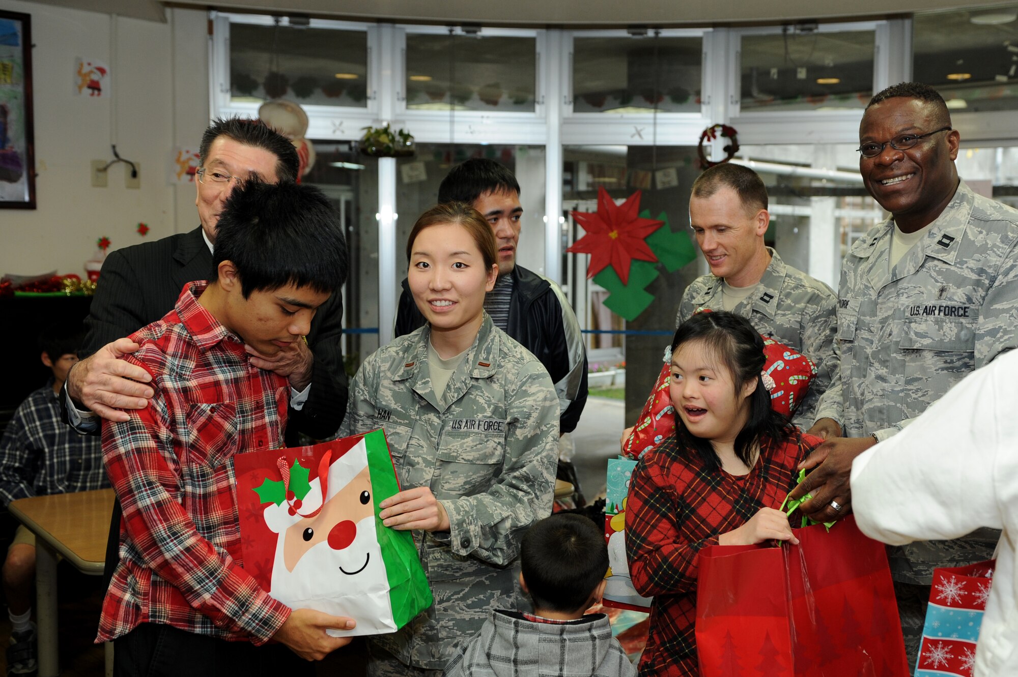 18th Chaplain Corps and 18th Contracting Squadron personnel participate in a gift exchange at the Okinawa Chuo Ikusei En facility for special needs on Okinawa, Japan, Dec. 20, 2013. Members of Kadena Air Base donated food and presents as part of an exchange for members with special needs during the holiday season. (U.S. Air Force photo by Airman 1st Class Hailey R. Staker)