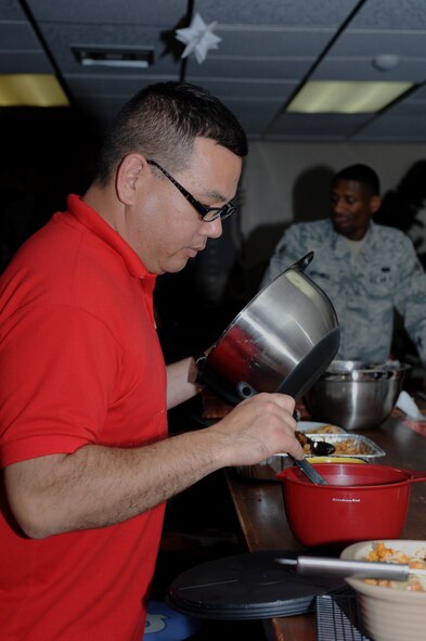 U.S. Air Force Capt. Craig Nakagawa, 18th Wing Chaplain Corps chaplain, prepares a meal during Ohana night at the Wired Bean on Kadena Air Base, Japan, Dec. 19, 2013. Ohana night is one of many activities offered by the Wired Bean where volunteers cook a homemade meal every Thursday and spend an evening with service members each week. (U.S. Air Force photo by Airman 1st Class Hailey R. Staker)