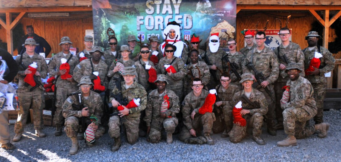 U.S. soldiers pose for a photograph on Forward Operating Base Gamberi, Afghanistan, Dec. 19, 2013, with their stockings full of gifts they received during a USO Christmas convoy stop.