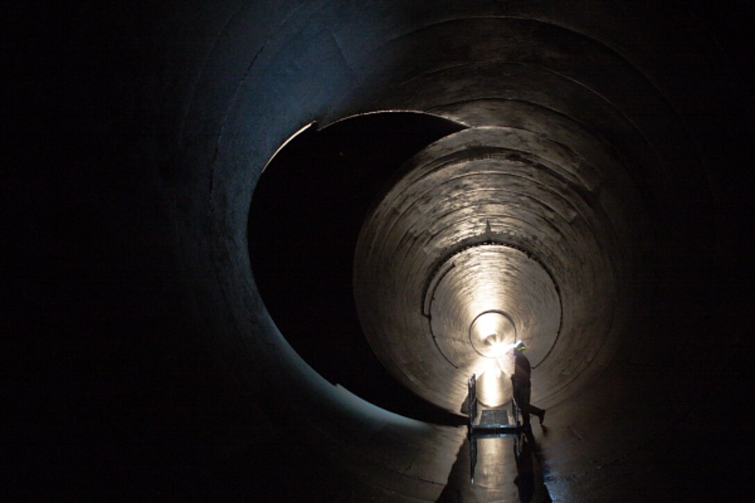 A maintenance worker stands in the Outlet Tunnel to Lucky Peak Dam.