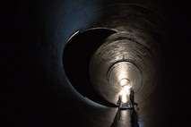 A maintenance worker stands in the Outlet Tunnel to Lucky Peak Dam.