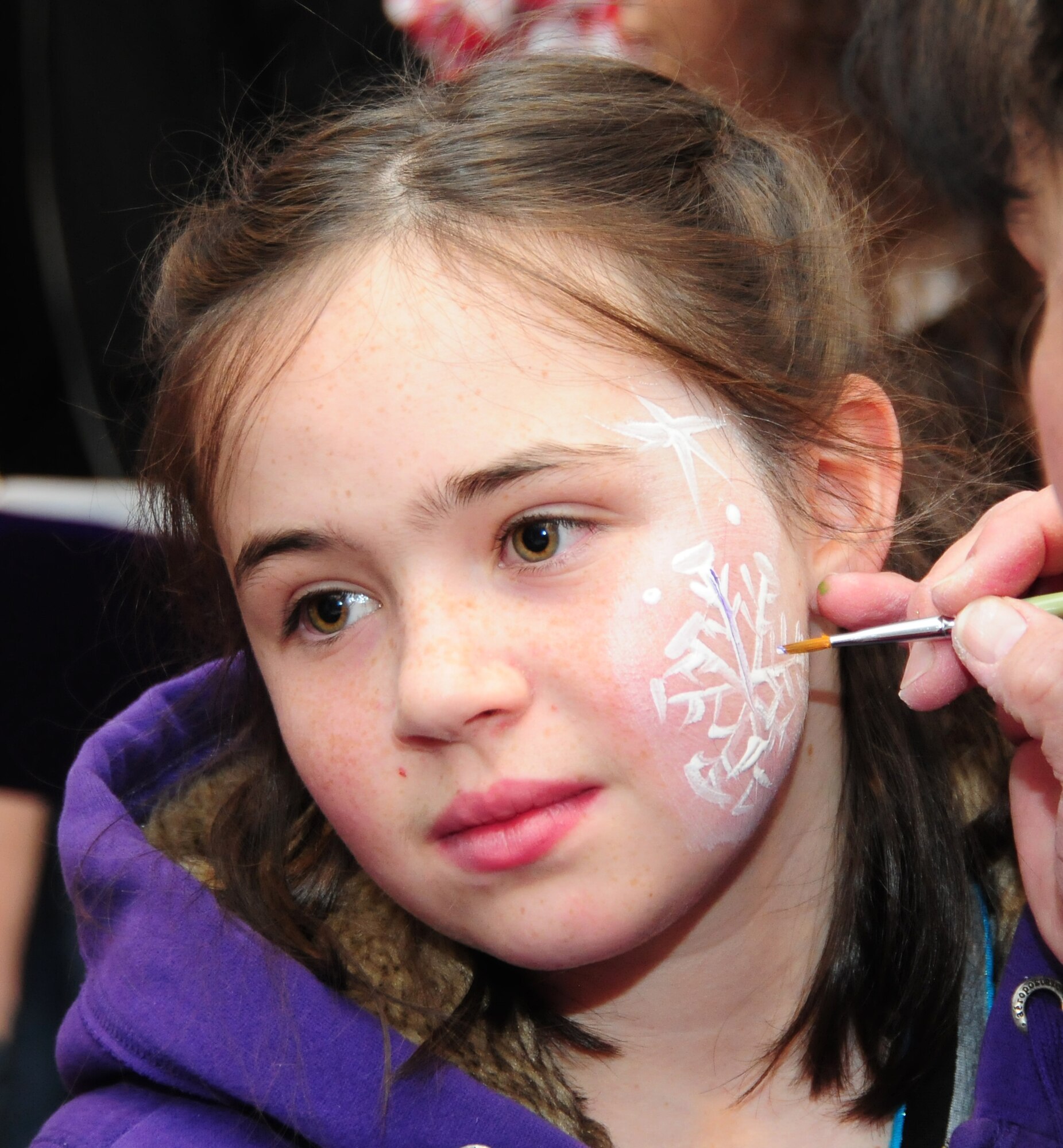 Hailey, 11, gets in the mood for the holiday season with a painted-on snowflake during the 310th Space Wing Junior Enlisted Council-sponsor "Breakfast with Santa" event Dec. 14 at Peterson Air Force Base, Colo. The event included the breakfast, pictures with Santa, a magic show and balloon animals for families apart of the Exceptional Family Member Program. Hailey is the daughter of Air Force Reserve Senior Airman Nolden Soerensen, a defensive space control operator with the 380th Space Control Squadron and vice president of the JEC. (U.S. Air Force photo/Tech. Sgt. Stephen J. Collier)