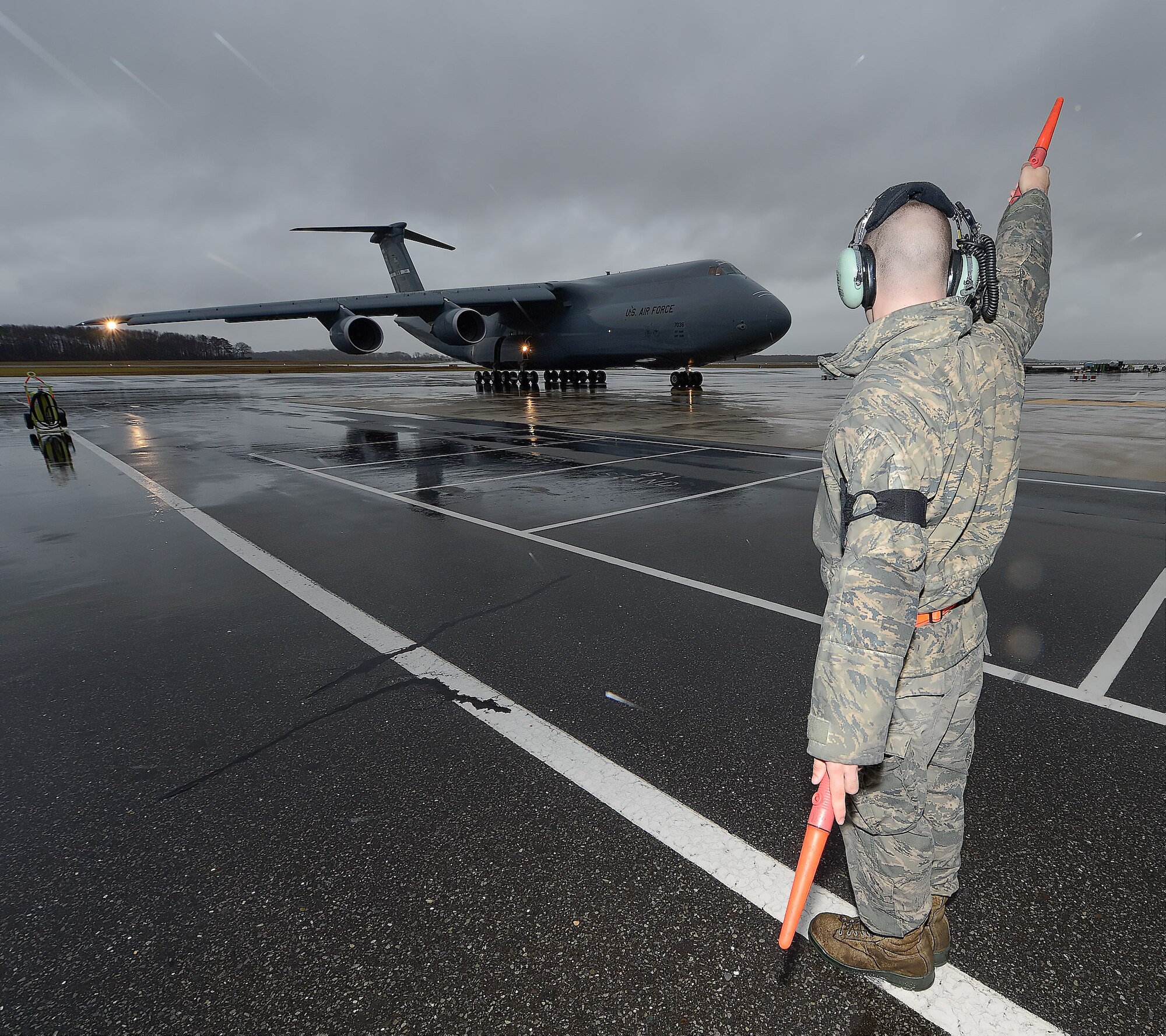 Senior Airman Brandon Dale, 436th Aircraft Maintenance Squadron crew chief, marshalls the 16th remanufactured C-5 Galaxy, serial # 87-0036, in to park at Dover Air Force Base, Del., after upgrade by Lockheed Martin Corp. in Marietta, Ga. on Dec. 23, 2013. The aircraft was formerly operated by the 60th Air Mobility Wing, 349th Air Mobility Wing (Air Force Reserve Command), Travis AFB, Calif., and still wears markings for the unit. Although the aircraft has completed the major airframe, engine and avionics upgrades for the C-5M configuration, it will soon be sent to Stewart Air National Guard Base, N.Y., for a complete interior upgrade. Upon completion of the interior upgrade then the aircraft will be considered fully mission configured and take on the C-5M Super Galaxy name. 87-0036, joins 15 additonal upgraded C-5s at the 436th Airlift Wing, currently the sole front-line transport Wing to operate the Super Galaxy. (U.S. Air Force photo/Greg L. Davis)