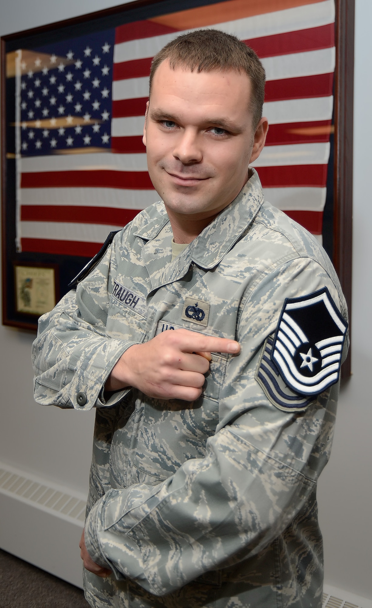 Master Sgt. Heath D. Traugh, 436th Aircraft Maintenance Squadron, points at the Master Sgt. chevrons taped to his sleeve after being step promoted on Dec. 24, 2013. A Stripes for Expectional Performers, or STEP promotion, recognizes exceptional performance and allows commanders to promote members out of cycle. (U.S. Air Force photo/Greg L. Davis)