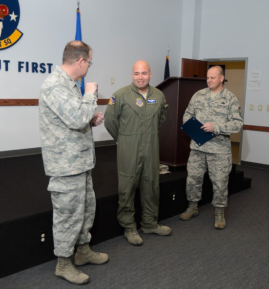Technical Sgt. Jose H. Cruz, a C-17A Loadmaster with the 3rd Airlift Squadron, reacts after being told he has just been step promoted, Dec. 24, 2013, by Colonel Rick Moore and Chief Master Sgt. Jim Smith at Dover Air Force Base, Del. As a C-17A loadmaster Cruz is responsible for the cargo aboard the aircraft. (U.S. Air Force photo/Greg L. Davis)