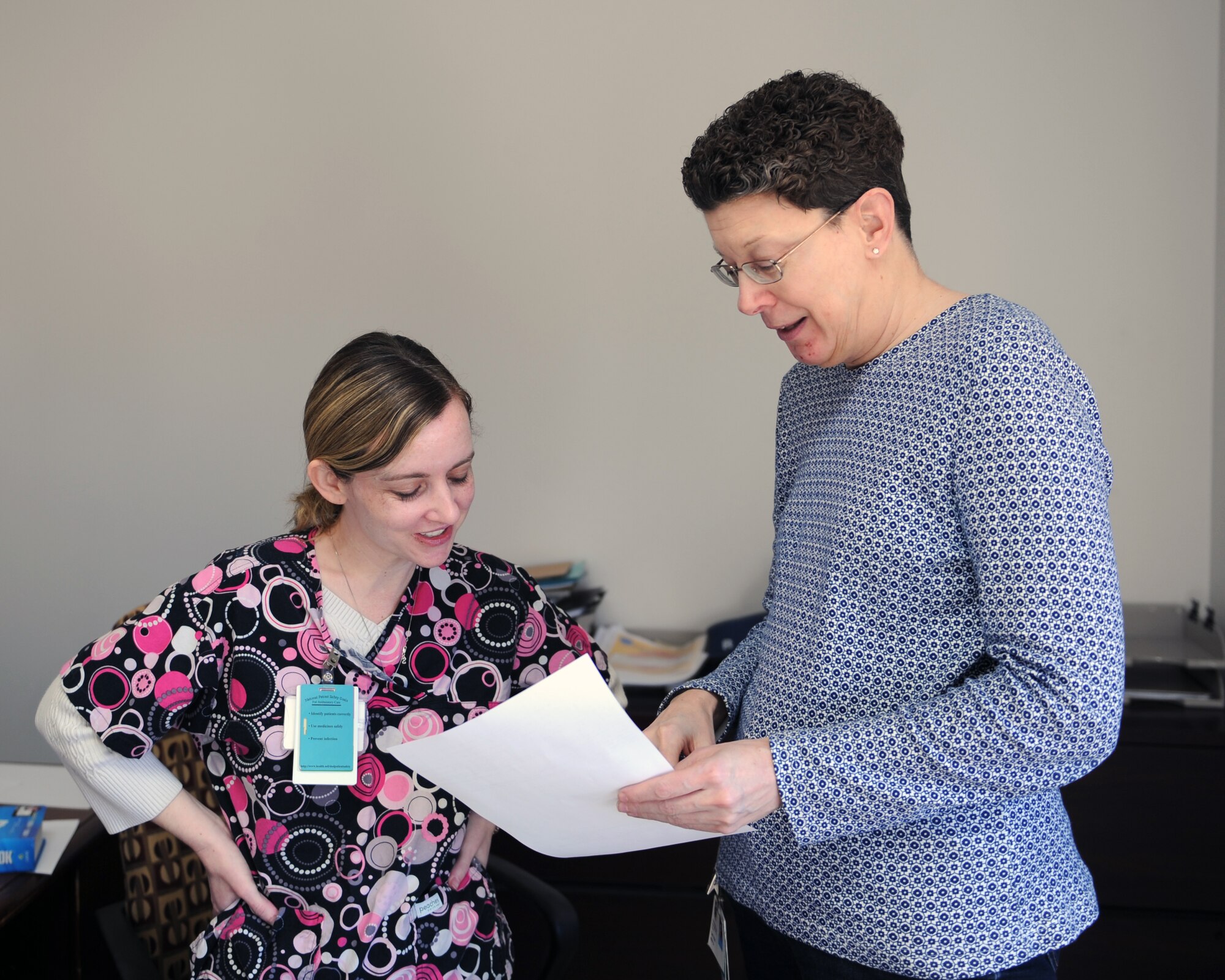 Misty Colmery, left, and Carol Mann, 7th Medical Group, view and discuss a patient's telephone consultation to resolve a situation Dec. 18, 2013, at Dyess Air Force Base, Texas. Some common situations that may cause a patient to call the patient advocacy line may have to do with existing telephone consultations or if there’s difficulty getting in touch with a specific medical department. (U.S. Air Force photo by Airman 1st Class Kedesha Pennant/Released)