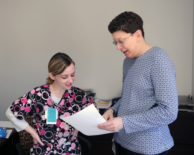 Misty Colmery, left, and Carol Mann, 7th Medical Group, view and discuss a patient's telephone consultation to resolve a situation Dec. 18, 2013, at Dyess Air Force Base, Texas. Some common situations that may cause a patient to call the patient advocacy line may have to do with existing telephone consultations or if there’s difficulty getting in touch with a specific medical department. (U.S. Air Force photo by Airman 1st Class Kedesha Pennant/Released)