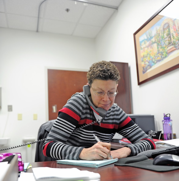 Carol Mann, 7th Medical Group Health Insurance Portability and Accountability Act manager, answers a call and takes down information in her office Dec. 5, 2013, at Dyess Air Force Base, Texas.   Mann serves as a patient advocate liaison to the 7th Medical Group here. The patient advocacy service is used to help patients resolve any issues or concerns they may have with their medical care or appointments in the medical group.  (U.S. Air Force photo by Airman 1st Class Kedesha Pennant/Released)