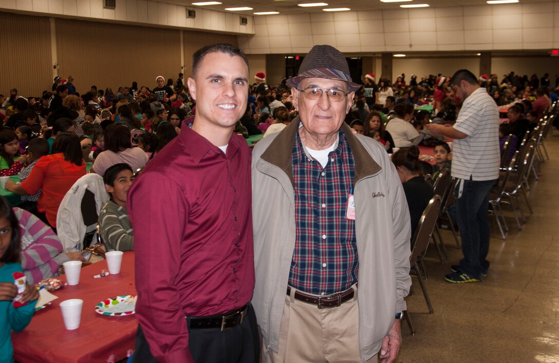 Capt. Greg Show, left, 85th Flying Training Squadron instructor pilot, poses for a photo with Claudio Sotelo, one of Ninos Navidenos’ founders and former Laughlin employee, at the Del Rio Civil Center Dec. 21. This year, Ninos Navidenos and Laughlin members were able to give nearly 900 underprivileged children presents during the holiday season. (U.S. Air Force photo/Joel Langton)