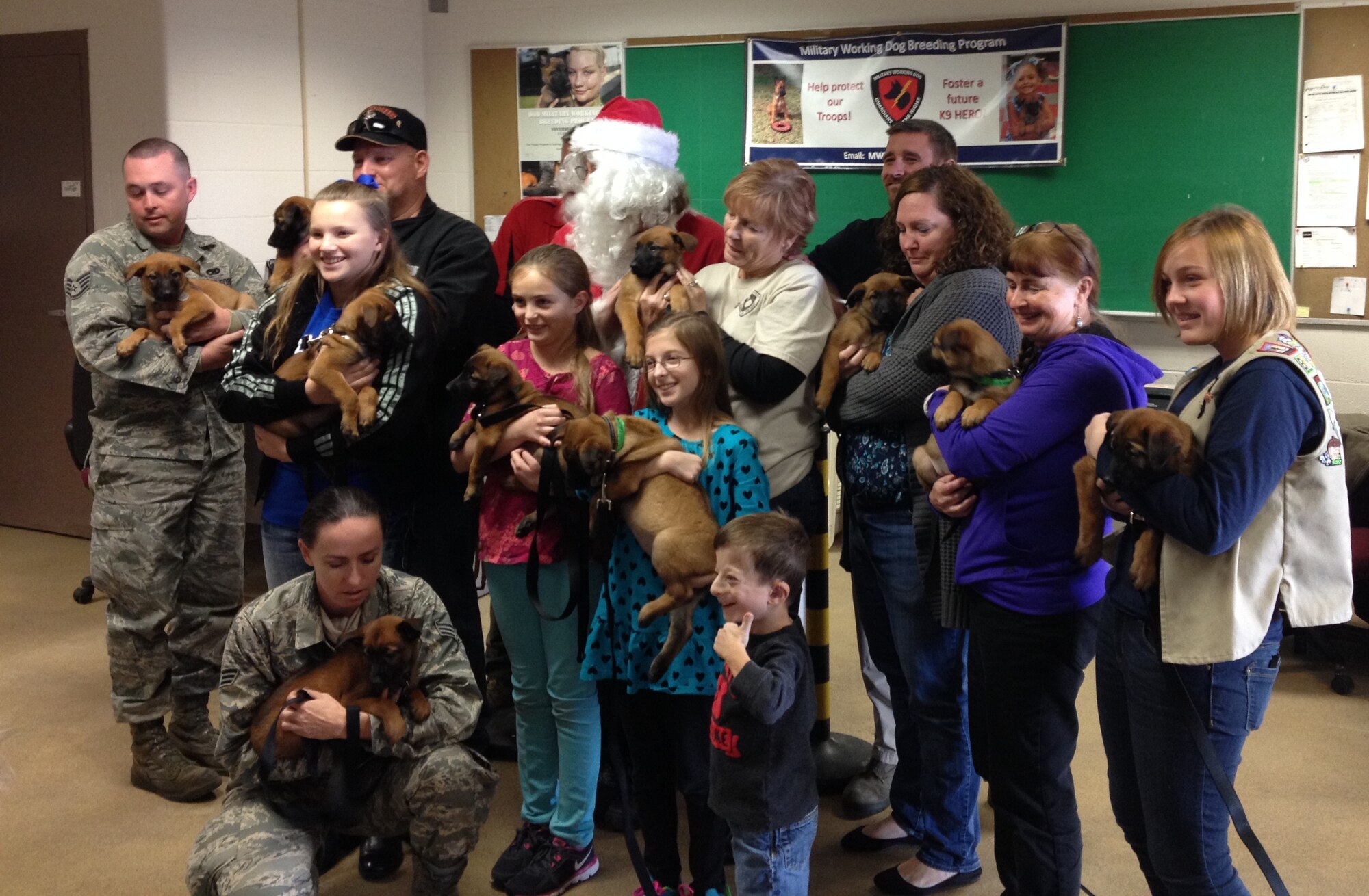 Fosters holding their TT4 and UU4 puppies after the completion of the foster orientation seminar at Joint Base San Antonio-Lackland, Dec. 11, 2013. 