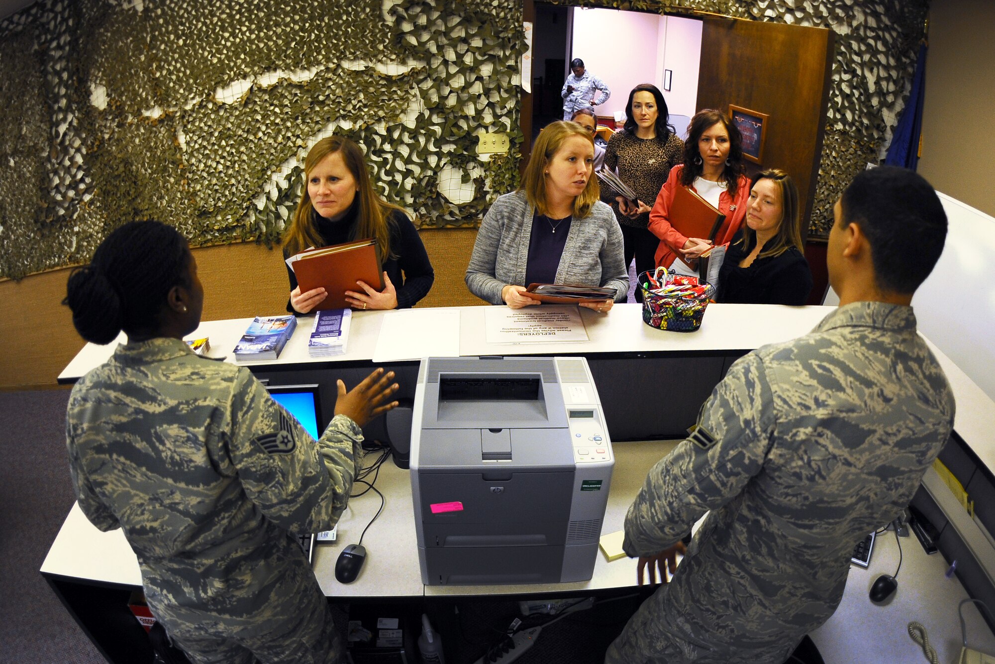 Offutt Key Spouses are greeted by Airman as they enter the mobility line following a mock deployment briefing held at the Mobility Processing Center on Dec. 19 at Offutt Air Force Base, Neb.  The key spouses are going to be a new fixture on the mobility line as Airman process for deployment.  (U.S. Air Force photo by Josh Plueger/Released)