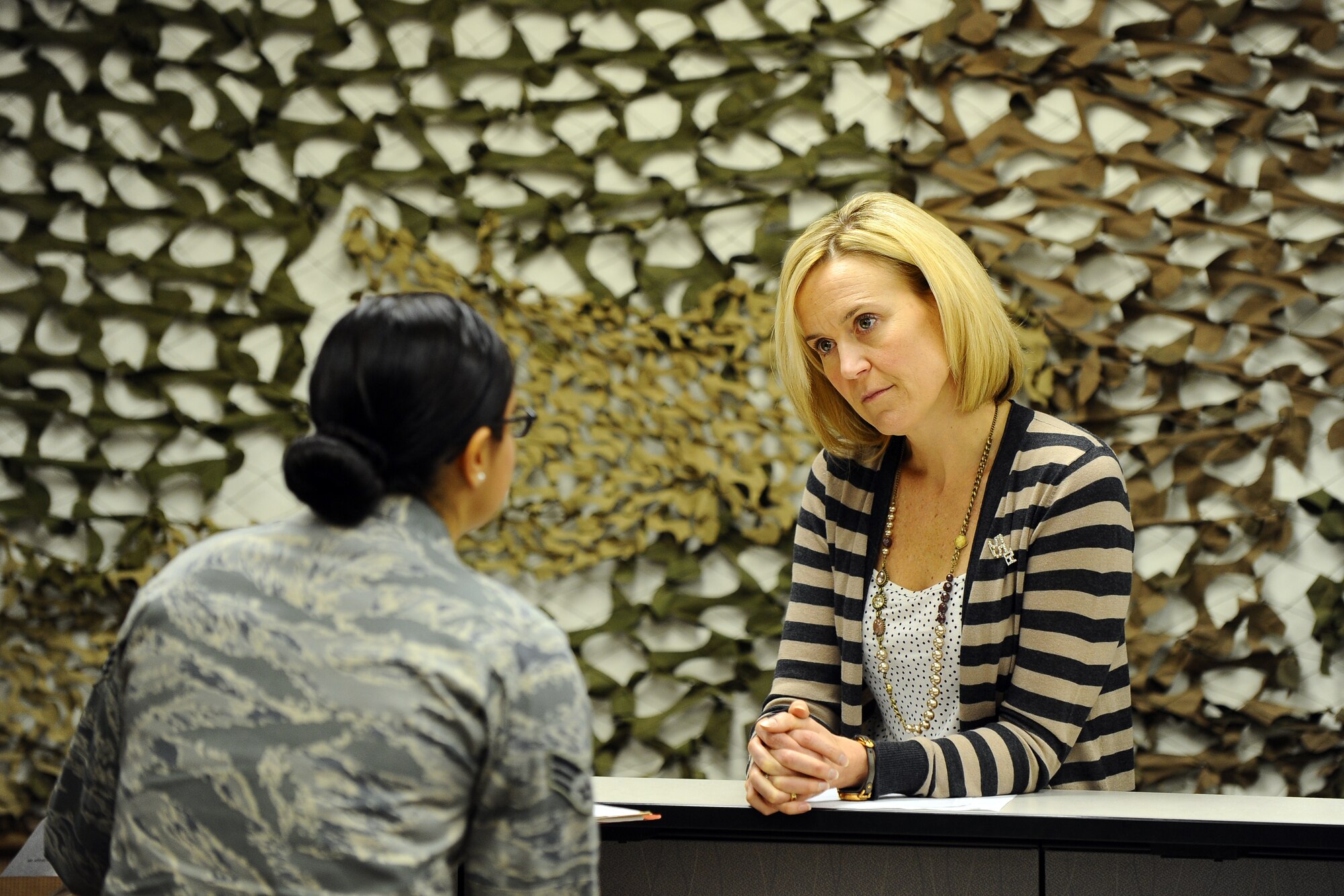 Caroline Guillot, wife of U.S. Air Force Col. Gregory M. Guillot, 55th Wing commander, meets with Senior Airman Anastacia Zamora, an installation personnel readiness journeyman with the 55th Logistics Readiness Squadron, while working her way through the mobility line during the Offutt Key Spouse deployment line exercise held at the Mobility Processing Center on Dec. 19 at Offutt Air Force Base, Neb. The key spouses will become an added stop on the mobility line as Airman are preparing for deployments.  (U.S. Air Force photo by Josh Plueger/Released)