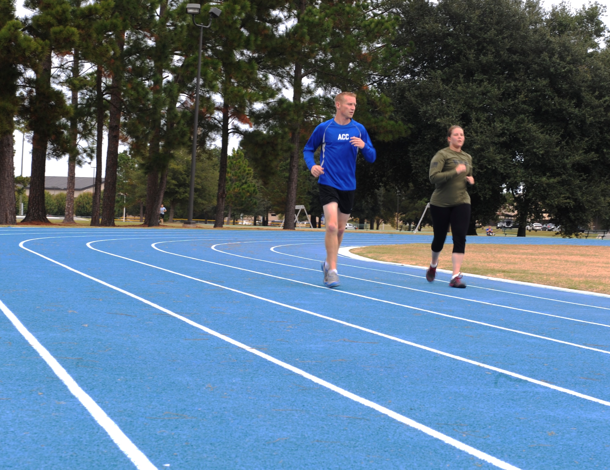 U.S. Air Force Tech. Sgt. Aaron Williams 372nd Training Squadron Det. 9 instructor, encourages Staff Sgt. Erin Miller, 23d Communications Squadron, during a sprint workout at Moody Air Force Base, Ga., Nov. 21, 2013. Williams uses his experience as a marathon runner to help others better themselves as runners. (U.S. Air Force photo by Senior Airman Olivia Bumpers/Released)