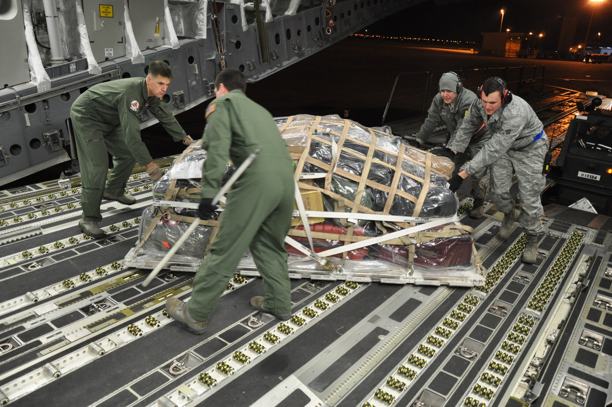 Tech. Sgt. Kyle Simpson, a loadmaster and full-time college student assigned to the 701st Airlift Squadron, Joint Base Charleston, S.C., assists in maneuvering palletized cargo aboard a C-17 Globemaster III aircraft prior to departing Incirlik Air Base, Turkey Dec. 22. (U.S. Air Force photo by Senior Airman Bobby Pilch/released)