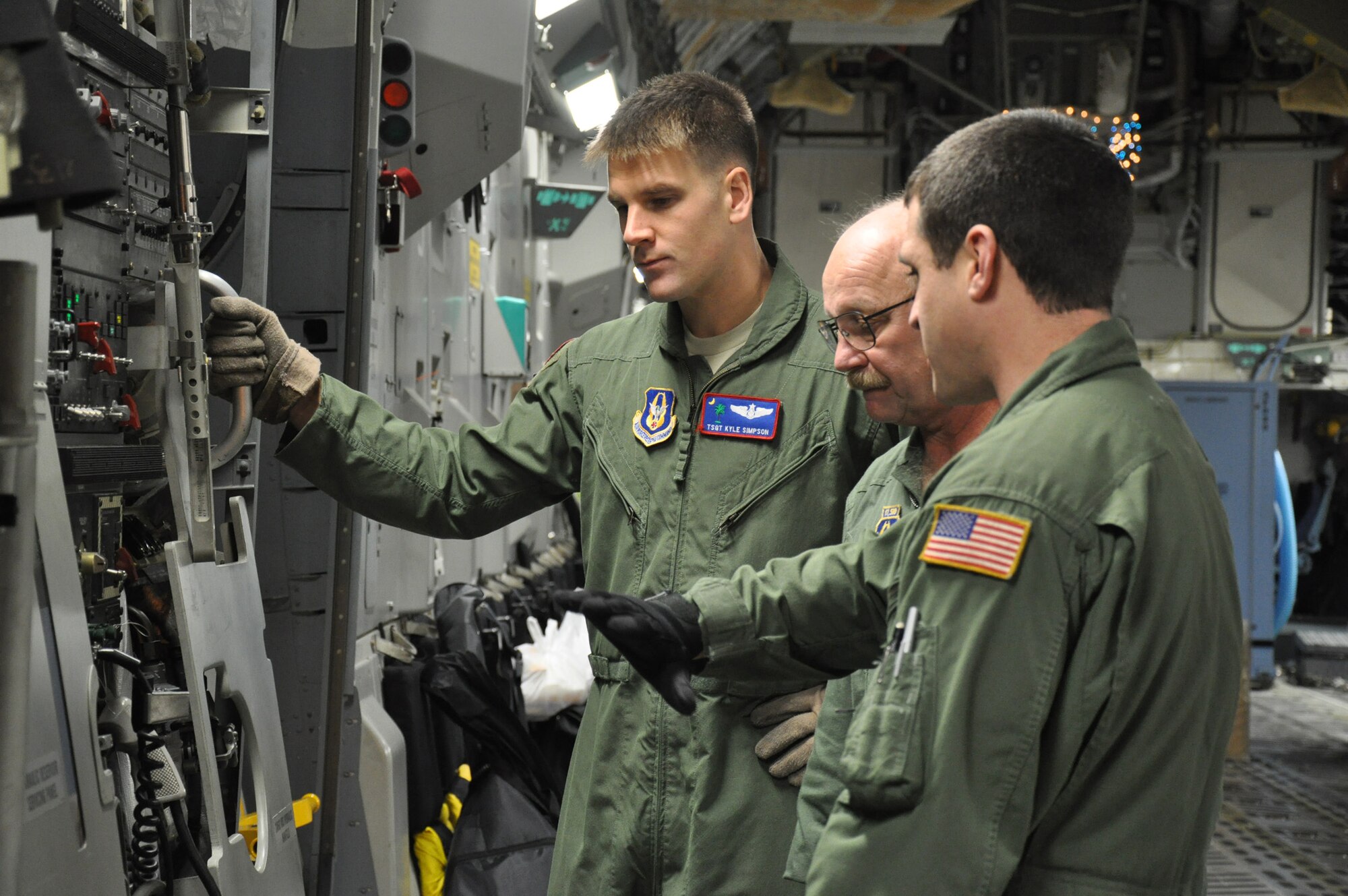 Master Sgt. Dennis Moore (middle), an air reserve technician with the 701st Airlift Squadron, Joint Base Charleston, S.C. provides technical instruction to Tech. Sgts. Kyle Simpson (left) and Shayne Katirgis (right), loadmasters assigned to the 701 AS, during their check ride from Incirlik Air Base, Turkey Dec. 22. (U.S. Air Force photo by Senior Airman Bobby Pilch/released)