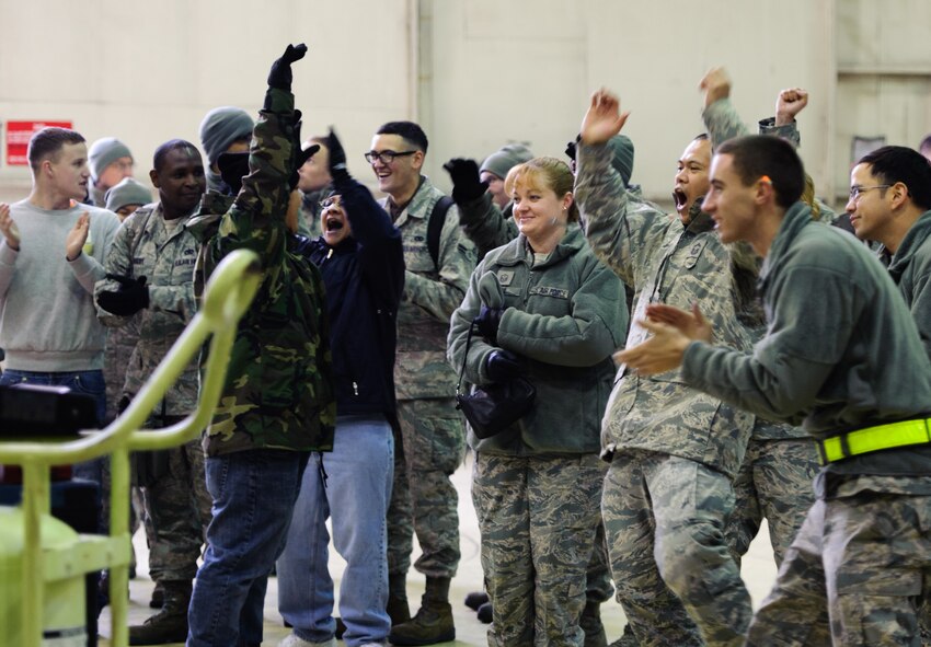 Airmen from the 80th Aircraft Maintenance Unit cheer their fellow Airmen on during the quarterly load competition at Kunsan Air Base, Republic of Korea, Dec. 20, 2013. The 8th Maintenance Squadron Weapons Standardization Section hosts load competitions to test the skills learned by Airmen and boost morale.  (U.S. Air Force photo by Senior Airman Armando A. Schwier-Morales/Released)