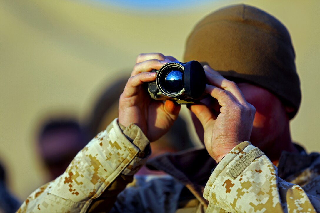 A U.S. Marine uses an optic lens to scan for improvised explosive devices as he learns how to mark improvised explosive devices on Camp Leatherneck in Afghanistan's Helmand province, Dec. 20, 2013.