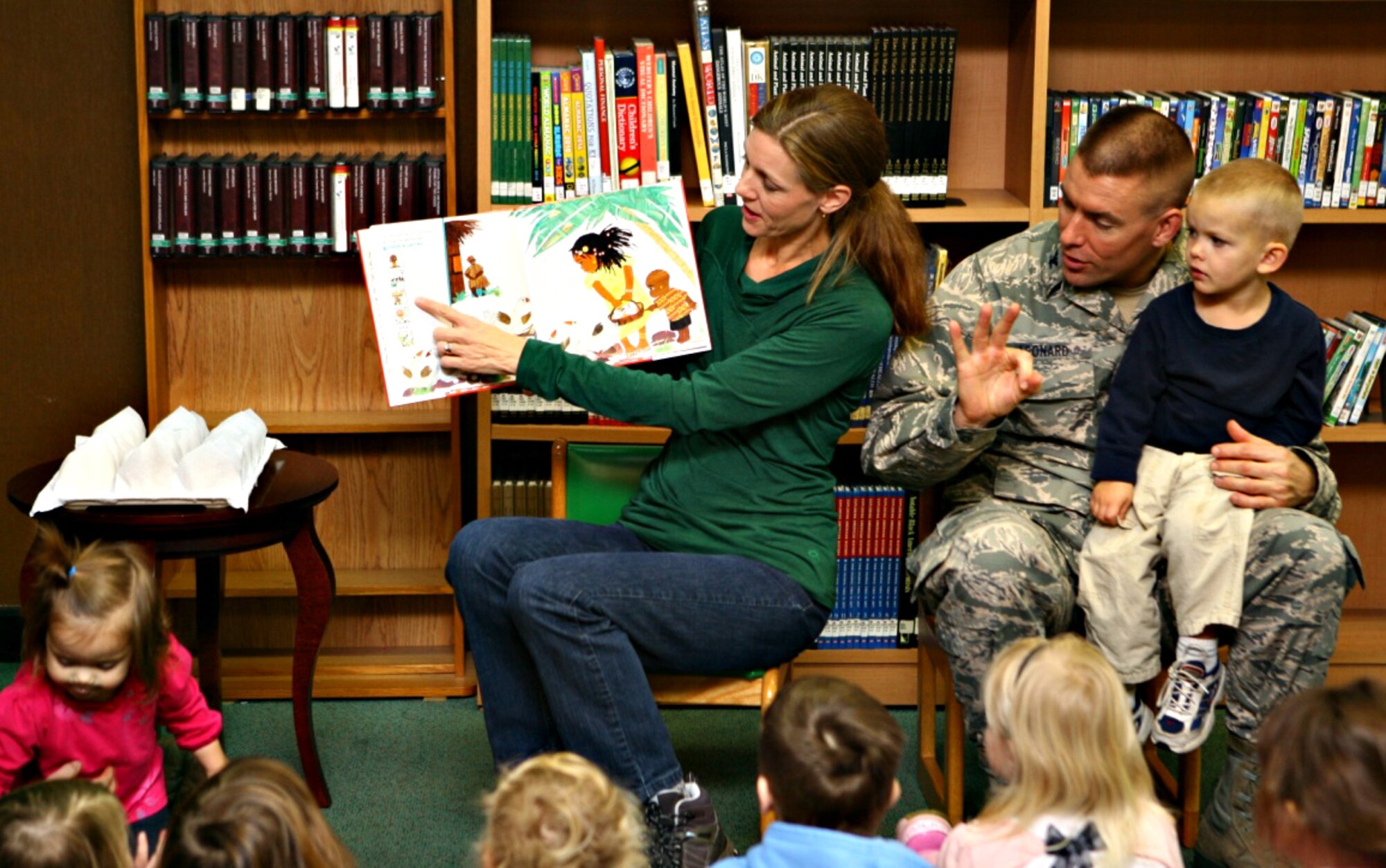 Maria Leonard, spouse of Col. Brook Leonard, 51st Fighter Wing commander, reads a holiday-themed story along with her husband to Osan children during a story time event as part of the 51st Force Support Squadron’s “12 Days of Customer Appreciation” in the library at Osan Air Base, Republic of Korea, Dec. 20, 2013. Dec. 20 was designated as the library’s day for customer appreciation during the week-long celebration. (U.S. Air Force photo/Airman 1st Class Ashley J. Thum) 