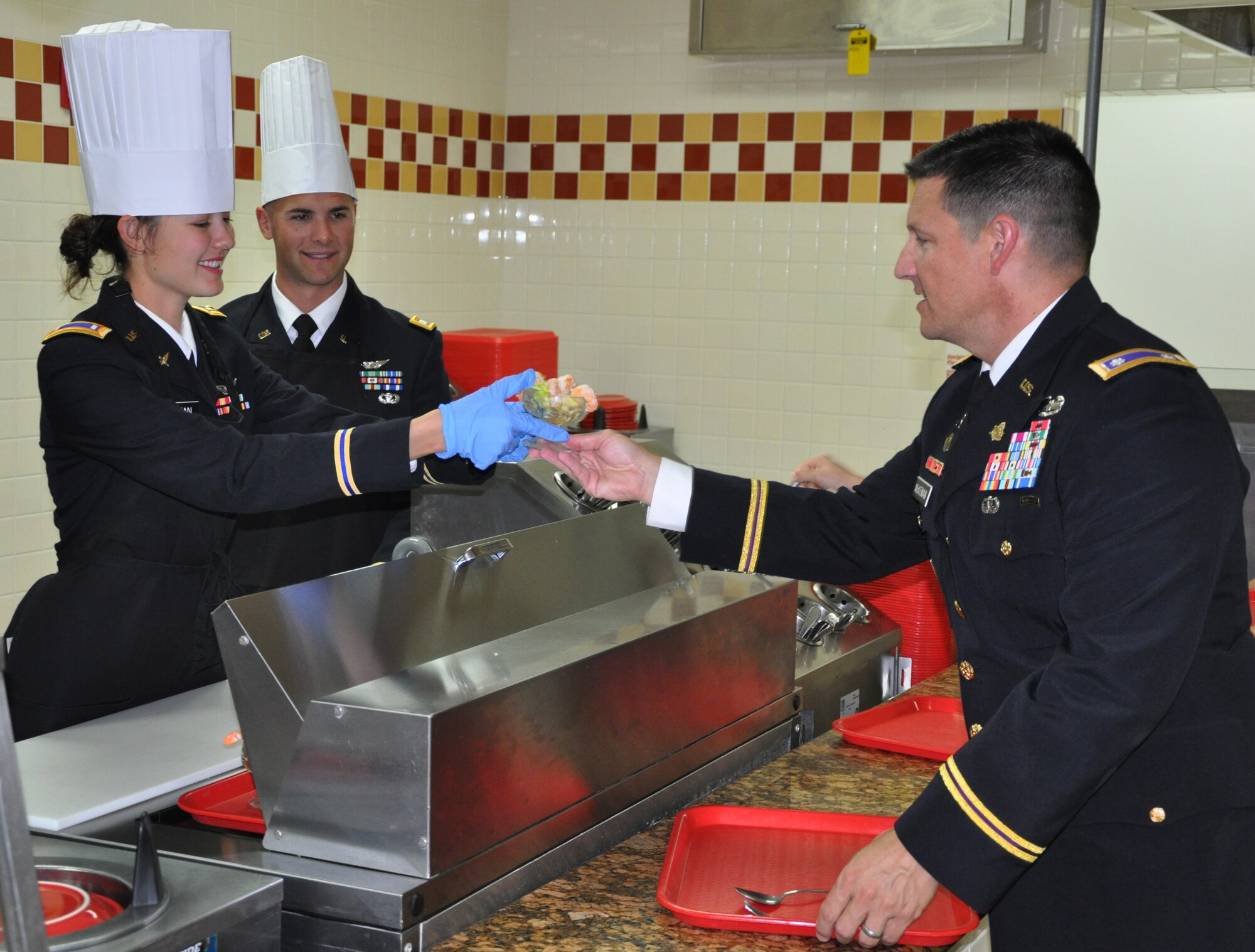 U.S. Army 2nd Lt. Lauren Rattan serves a shrimp cocktail to U.S. Army Lt. Col. Alan McKewan at the dining facility at Soto Cano Air Base, Honduras, Dec. 25, 2013.  Members of Joint Task Force-Bravo were treated to a Christmas Day meal with all the trimmings today.  Leadership from across Joint Task Force-Bravo, to include the Army Support Activity, Army Forces Battalion, Joint Security Forces, 612th Air Base Squadron, 1-228th Aviation Regiment, and Medical Element wore their dress uniforms and served the members of the Task Force. (U.S. Air Force photo by Capt. Zach Anderson)
 
 