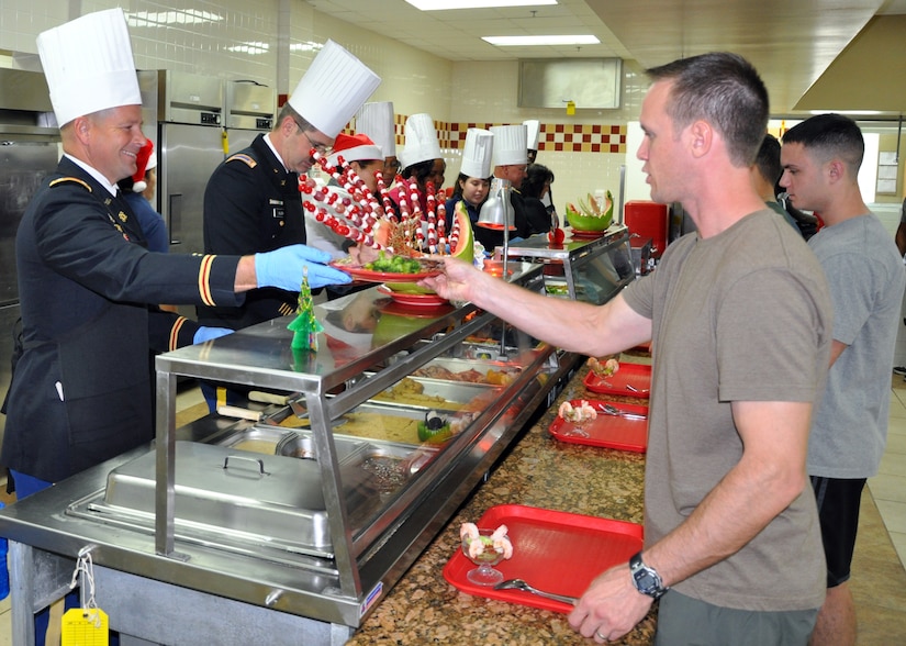 U.S. Army Lt. Col. Chris Meredith serves a up a plate of traditional holiday fare at the dining facility, Soto Cano Air Base, Honduras, Dec. 25, 2013.  Members of Joint Task Force-Bravo were treated to a Christmas Day meal with all the trimmings today.  Leadership from across Joint Task Force-Bravo, including the Army Support Activity, Army Forces Battalion, Joint Security Forces, 612th Air Base Squadron, 1-228th Aviation Regiment, and Medical Element wore their dress uniforms and served the members of the Task Force. (U.S. Air Force photo by Capt. Zach Anderson)
 