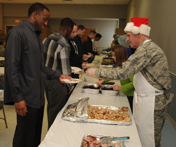 Lt. Gen. Stephen Wilson, Air Force Global Strike Command commander, serves food to Airman 1st Class Irthgar Berry, 2nd Comptroller Squadron customer service technician, during a Christmas lunch on Barksdale Air Force Base, La., Dec. 25, 2013. Commanders, chiefs and first sergeants as well as volunteers from several base organizations took time away from their families to prepare and serve a Christmas meal to dorm Airmen who were unable to go home for the holiday. (U.S. Air Force photo/Staff Sgt. Sean Martin)