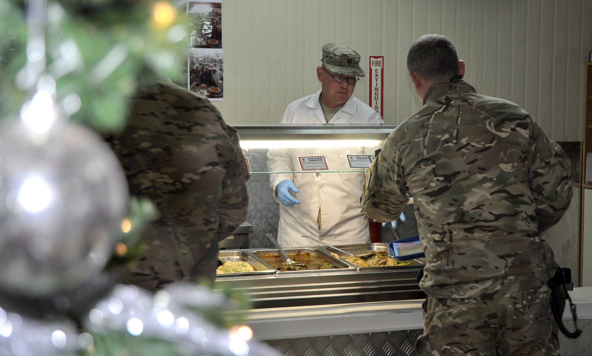 Command Sgt. Maj. Lawrence Leising, Commander, Kandahar Airfield command sergeant major, serves a Christmas meal to a service member at the Luxembourg Dining Facility, KAF, Afghanistan, Dec. 25, 2013. The meal included traditional Christmas foods like turkey, prime rib (roast beef), stuffing and deserts. (U.S. Air Force photo by Capt. Jason Smith)