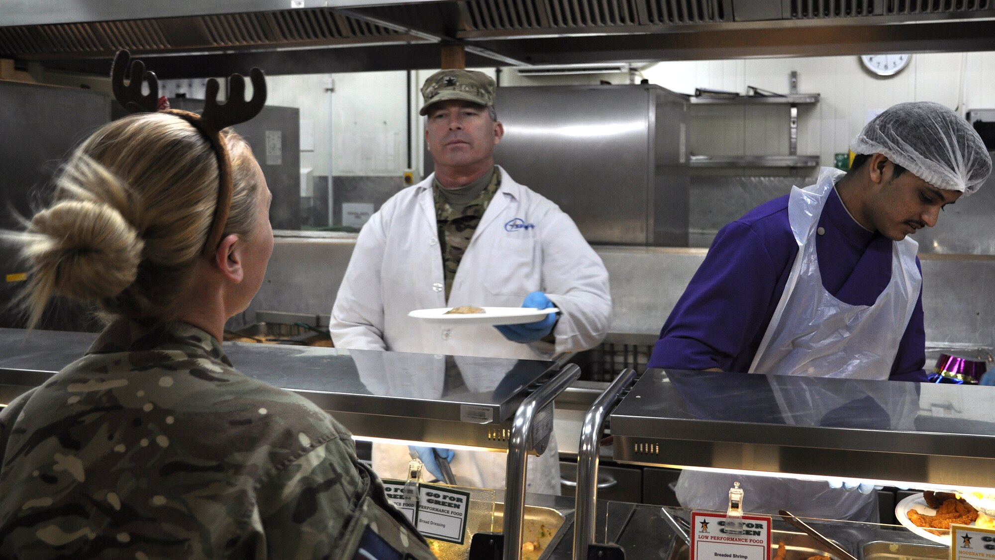 Brig. Gen. Michael Fantini (center), 451st Air Expeditionary Wing commander and Commander, Kandahar Airfield, serves a Christmas meal to a service member at the Luxembourg Dining Facility, KAF, Afghanistan, Dec. 25, 2013. The meal included traditional Christmas foods like turkey, prime rib, stuffing and deserts. (U.S. Air Force photo by Capt. Jason Smith)