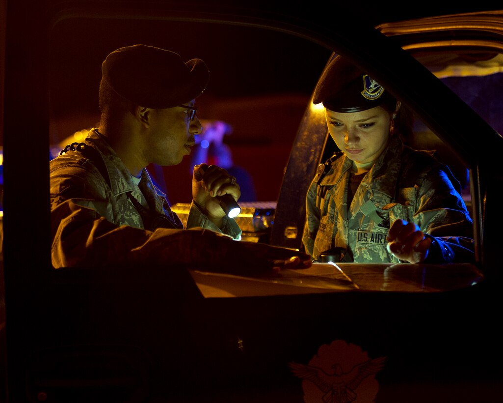 Staff Sgt. Matthew Boyd, left, and Airman 1st Class Sheridyn Webb review an airfield map during a simulated security incident Aug. 28, 2013, on the flightline at Altus Air Force Base, Okla. Boyd and Webb are assigned to the 98th Security Forces Squadron. (U.S. Air Force photo/Senior Airman Kenneth W. Norman)