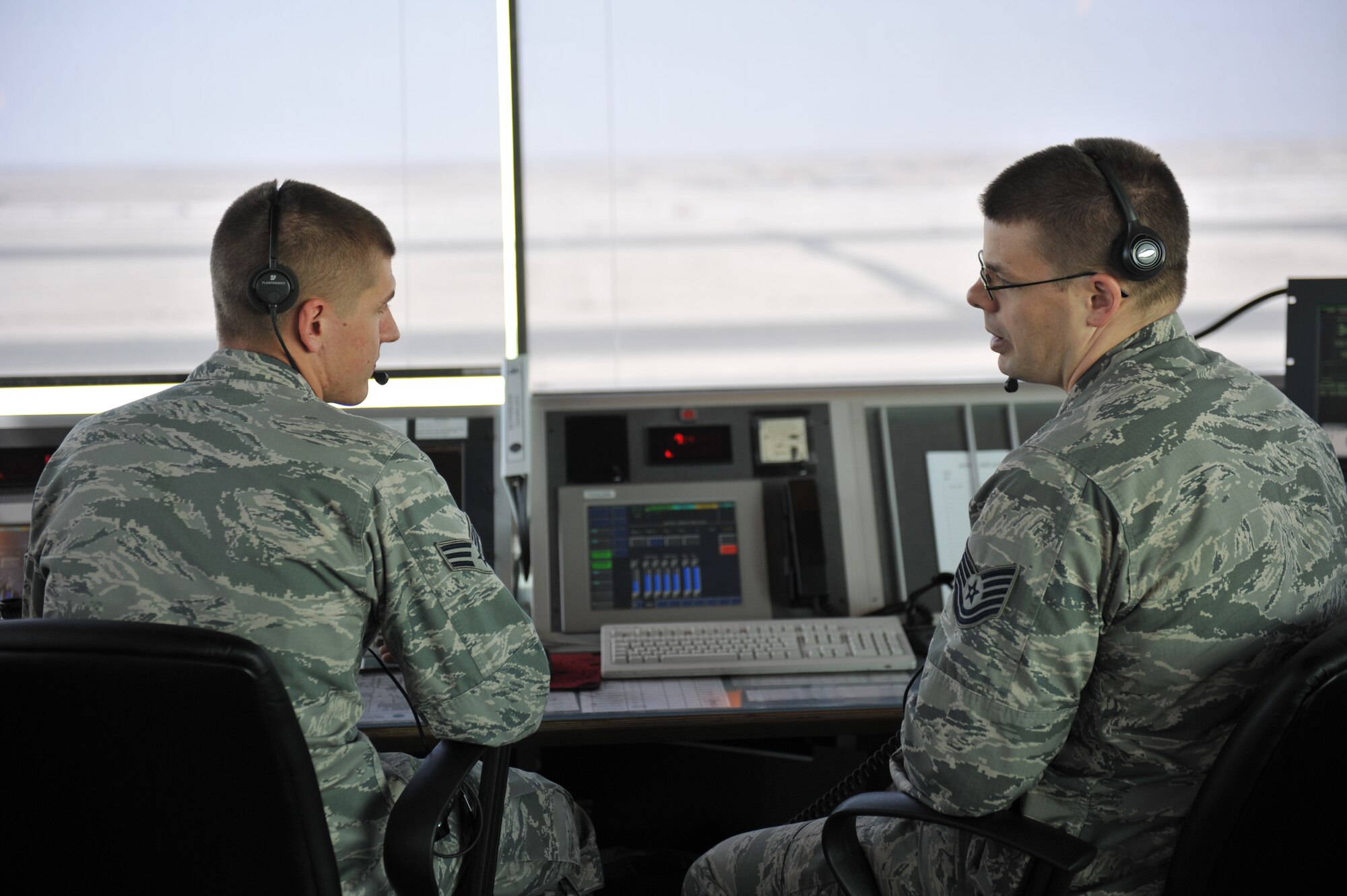 Tech. Sgt. Thomas Miller and Senior Airman Zachary Hutchings discuss flight plans in the air traffic control tower at the 379th Air Expeditionary Wing in Southwest Asia, Dec. 18, 2013. Miller and Hutchings are air traffic controllers who help provide 24-hour support to aircraft in flight and on the flightline. Miller is a 379th Expeditionary Operations Support Squadron air traffic controller deployed from Whiteman Air Force Base, Mo., and an Olathe, Kan., native. Hutchings is a 379th EOSS air traffic controller deployed from MacDill Air Force Base, Fla., and a Moline, Ill., native. (U.S. Air Force photo by Master Sgt. David Miller)