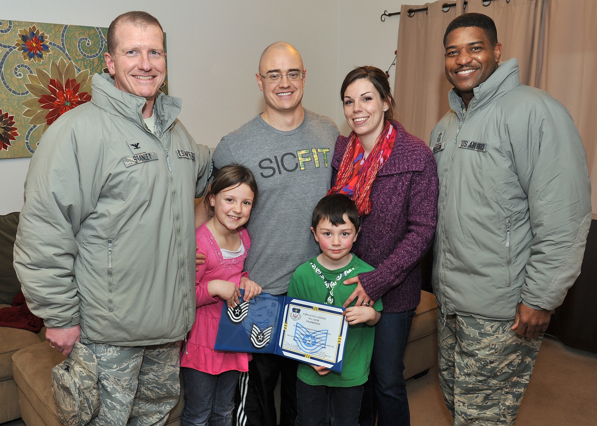Col. Robert Stanley, 341st Missile Wing commander (left), and Chief Master Sgt. Phillip Easton, 341st MW command chief (right), pose with Staff. Sgt. Christian Nichols, 341st Force Support Squadron Airmen Leadership School instructor (center), and his family after being notified of his Stripes for Exceptional Performance promotion to technical sergeant Dec. 23. Nichols’ family are wife, Jinnie, daughter, Kylie and son, Christian. (U.S. Air Force photo/John Turner)