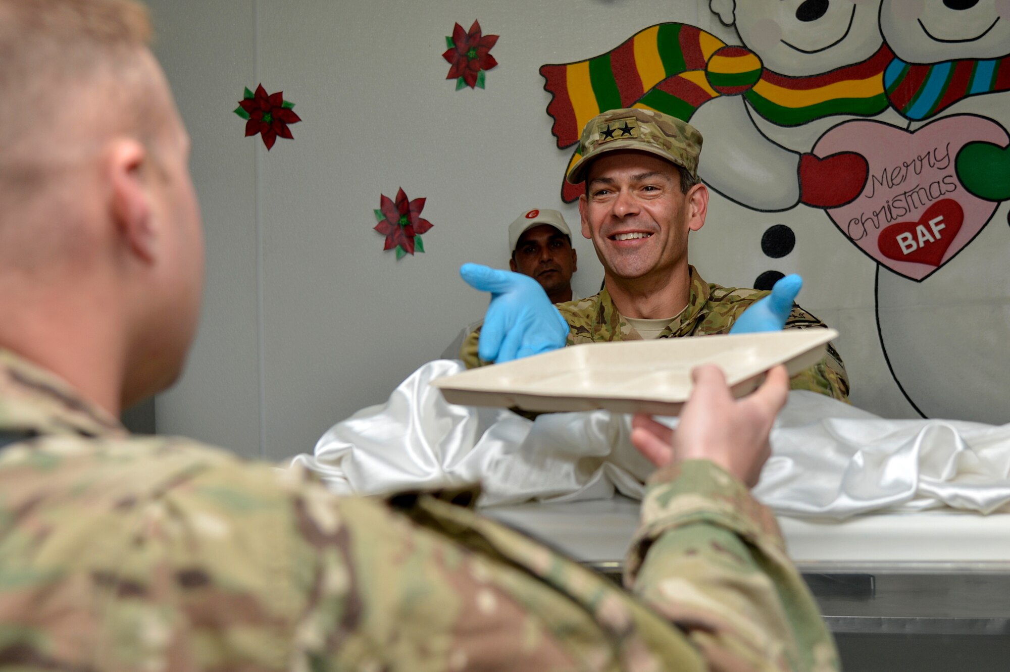 U.S. Air Force Maj. Gen. Kenneth Wilsbach, 9th Air and Space Expeditionary Task Force- Afghanistan; Deputy Commander -Air, U.S. Forces - Afghanistan; Deputy Chief of Staff - Air, International Security Assistance Force Joint Command, serves Christmas dinner at the Dragon Dining Facility at Bagram Airfield, Afghanistan, Dec. 25, 2013. During the day, Wilsbach visited with Service members at an entry control point, the C-130 ramp, the F-16 Fighting Falcon hangar, the A-10 Thunderbolt II hangar and the HH-60G Pavehawk hangar and the Craig Joint Theater Hospital. (U.S. Air Force photo by Senior Airman Kayla Newman/Released)