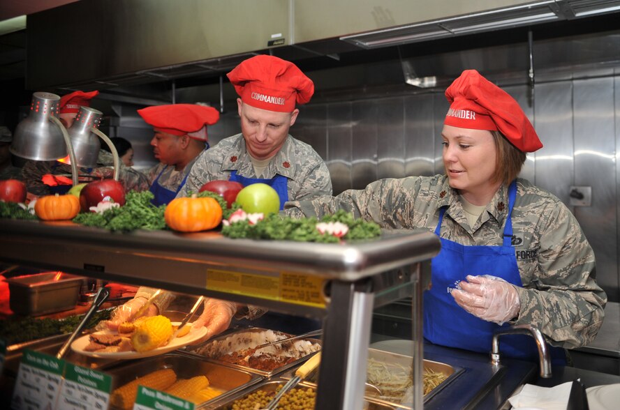 Maj. Susan Sheets, 51st Comptroller Squadron commander, and Maj. Eric Haler, 51st Logistics Readiness Squadron commander, fix up a plate during the Christmas meal in the Gingko Tree dining facility at Osan Air Base, Republic of Korea, Dec. 25, 2013. Every year, Osan leadership continues the tradition of serving Airmen and Soldiers their holiday meals. (U.S. Air Force photo/Airman 1st Class Ashley J. Thum)