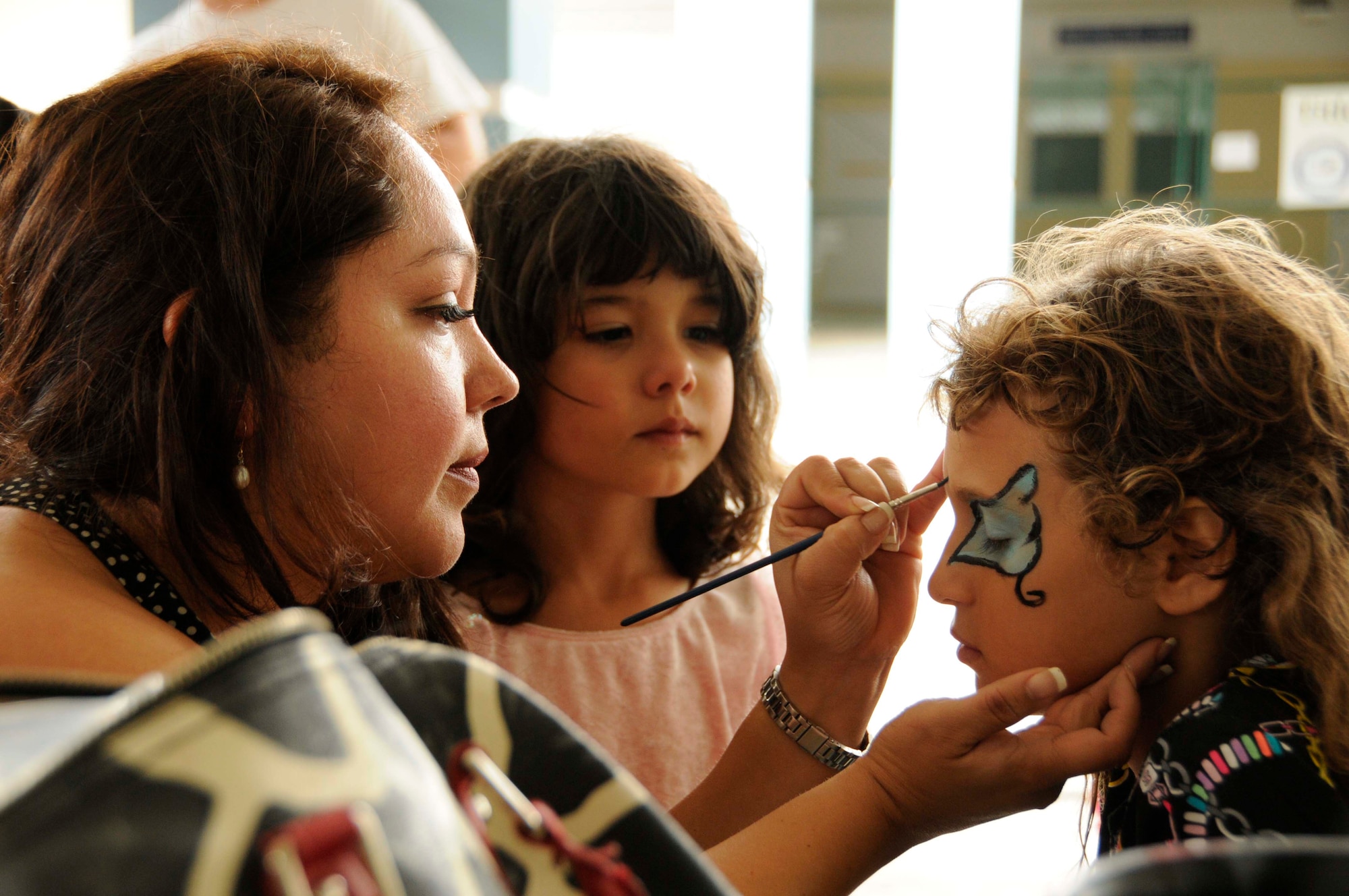 Volunteers from Homestead Air Reserve Base apply face paint on children at the Chapman Partnership in Homestead, Fla., Dec. 25. In addition to face painting, members from the base helped serve food and supported other fun activities. (U.S. Air Force photo/Senior Airman Nicholas Caceres)