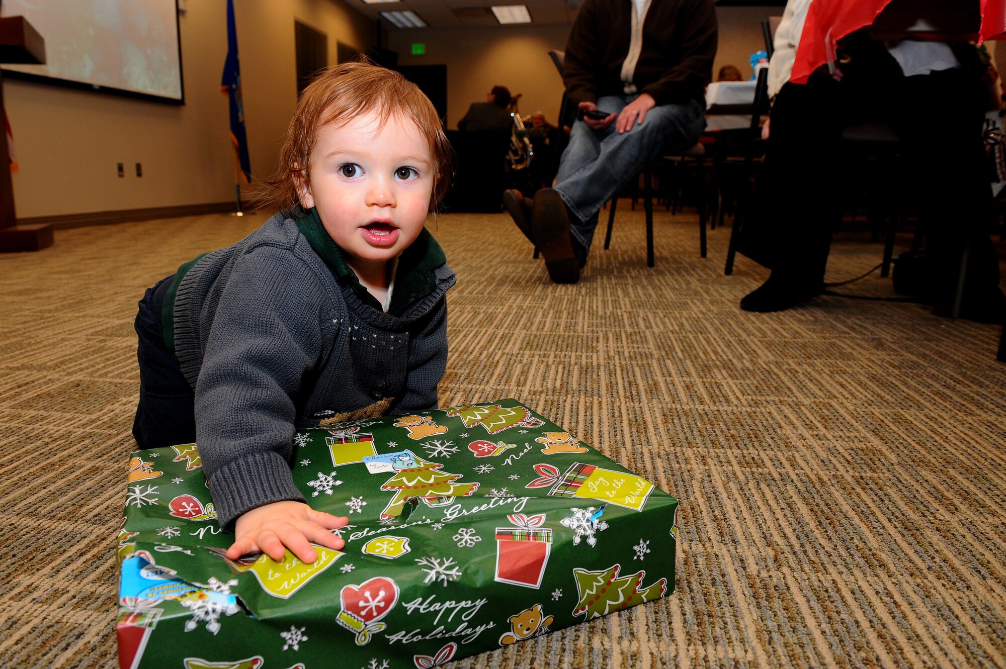 Theodore rips off the wrapping on a gift Dec. 20, 2013, at the chapel on Buckley Air Force Base, Colo. The gathering is an event that allows the families of deployed-servicemembers to meet with and enjoy the company of others. The holiday celebration included a catered dinner, presents for the children, live music and several door prizes. (U.S. Air Force photo by Senior Airman Phillip Houk/Released)