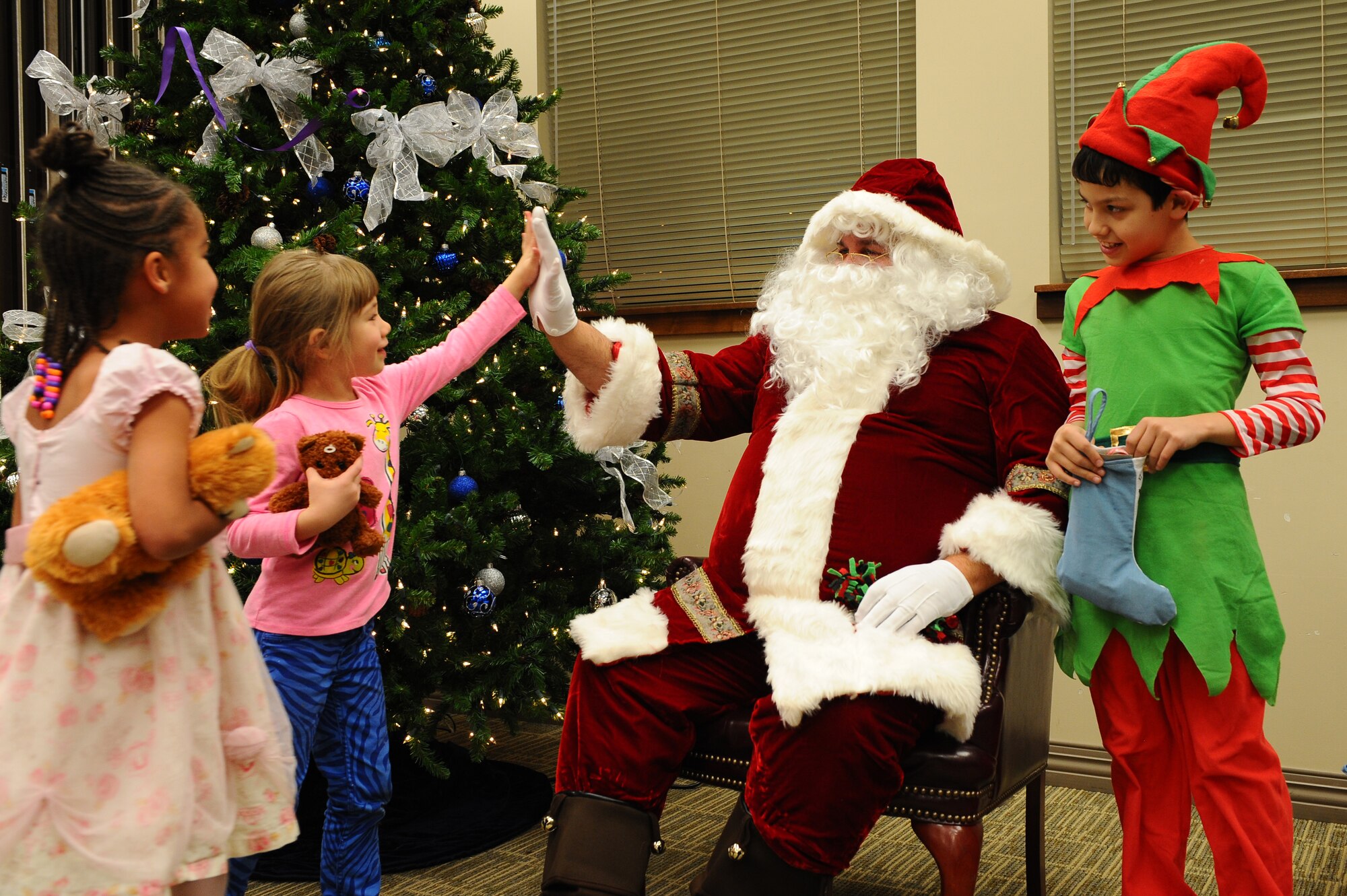 Santa Claus greets the children of deployed-military members at the deployed family event Dec. 20, 2013, at the chapel on Buckley Air Force Base, Colo. The gathering is an event that allows the families of deployed-servicemembers to meet with and enjoy the company of others. The holiday celebration included a catered dinner, presents for the children, live music and several door prizes. The Salvation Army provided Santa’s gifts, allowing every child to receive a present. (U.S. Air Force photo by Senior Airman Phillip Houk/Released)