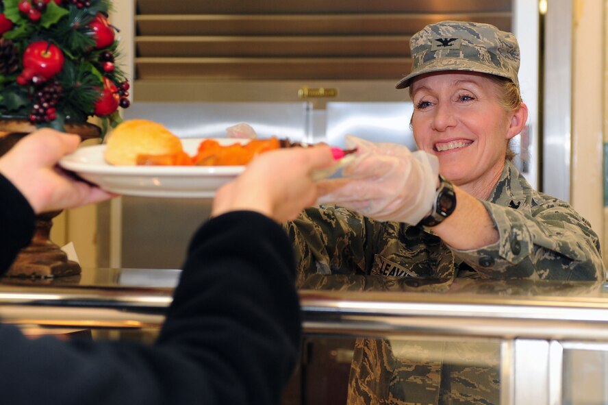 Col. Jeannie Leavitt, 4th Fighter Wing commander, hands off a plate of food at the Southern Eagle Dining Facility on Seymour Johnson Air Force Base, N.C., Dec. 25, 2013. Leavitt, along with several group commanders, squadron commanders and chiefs, volunteered on Christmas Day to put together holiday meals for Team Seymour. (U.S. Air Force photo by Senior Airman John Nieves Camacho)