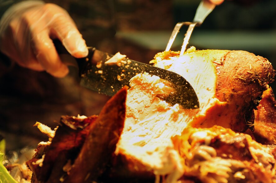 Maj. Nelson Aviles Figueroa, 4th Communications Squadron commander, slices turkey at the Southern Eagle Dining Facility on Seymour Johnson Air Force Base, N.C., Dec. 25, 2013. Wing leadership came out on Christmas Day to serve holiday meals to Airmen on base. (U.S. Air Force photo by Senior Airman John Nieves Camacho)